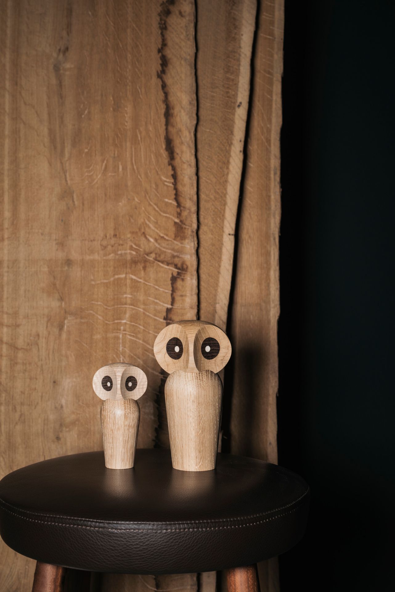Zwei Architectmade Holzfiguren Eulen auf einem Hocker, dekorative Holzobjekte für Wohnaccessoires.