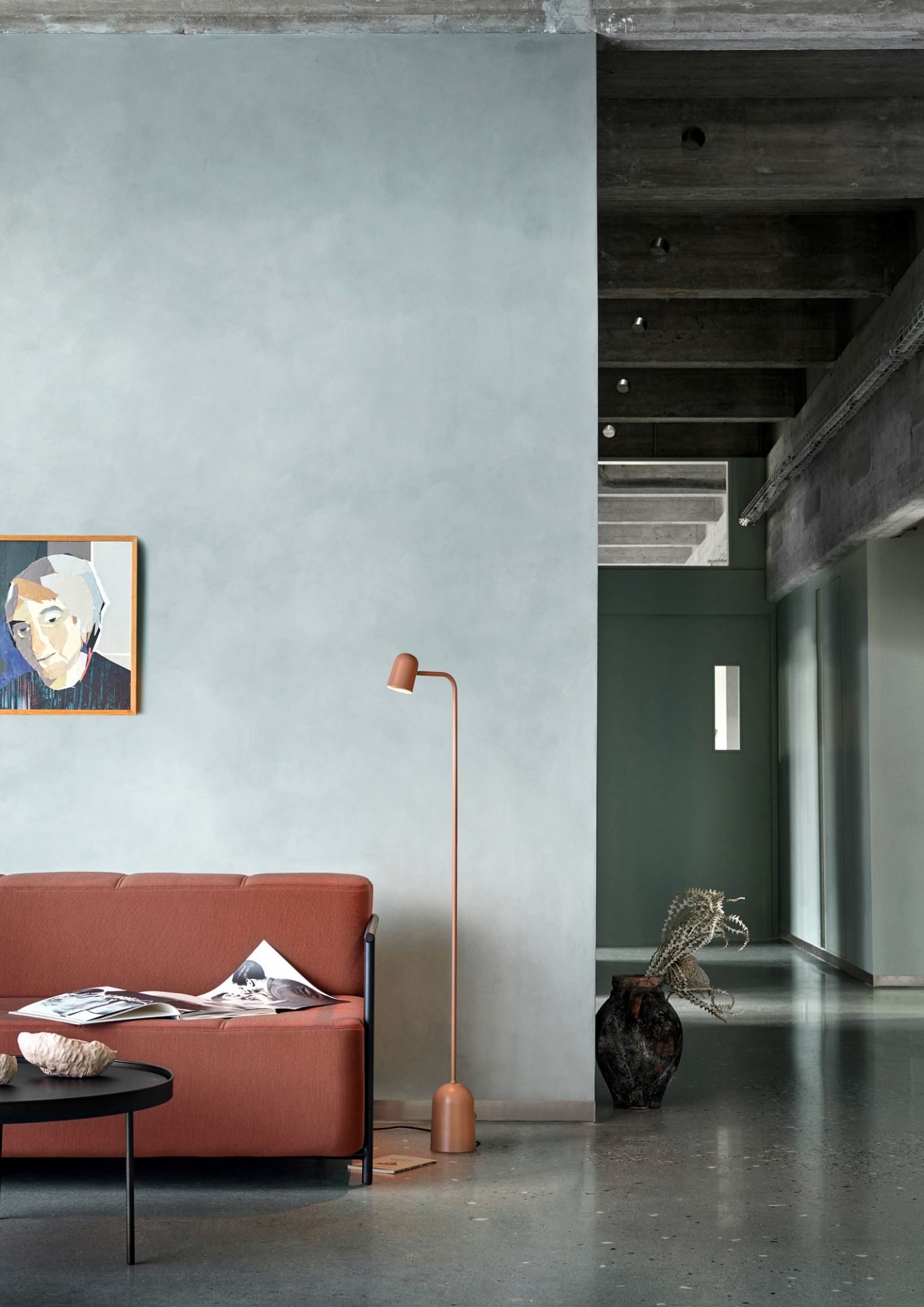Buddy Floor Stehleuchte von Northern in Kupfer neben Sofa und Beistelltisch in modernem Wohnraum.