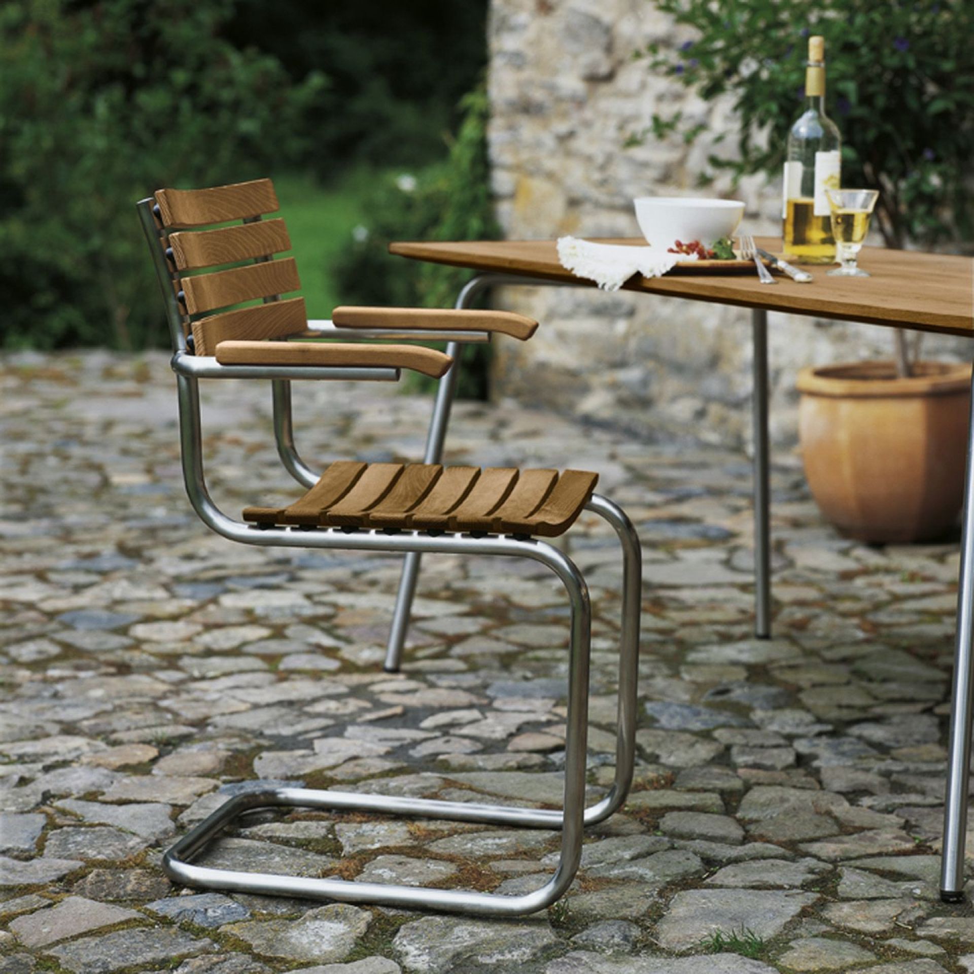 Thonet S 40 Freischwinger Gartenstuhl mit Holzlatten und Stahlrohrgestell im Außenbereich.