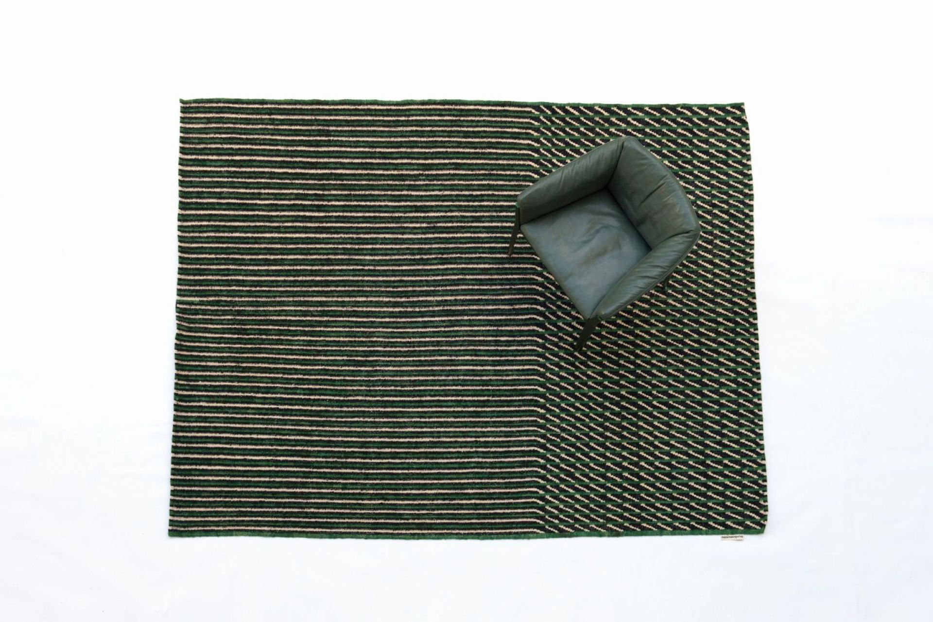 Grüner Blur Teppich (200x300 cm) von Nanimarquina mit Streifenmuster und Sessel.