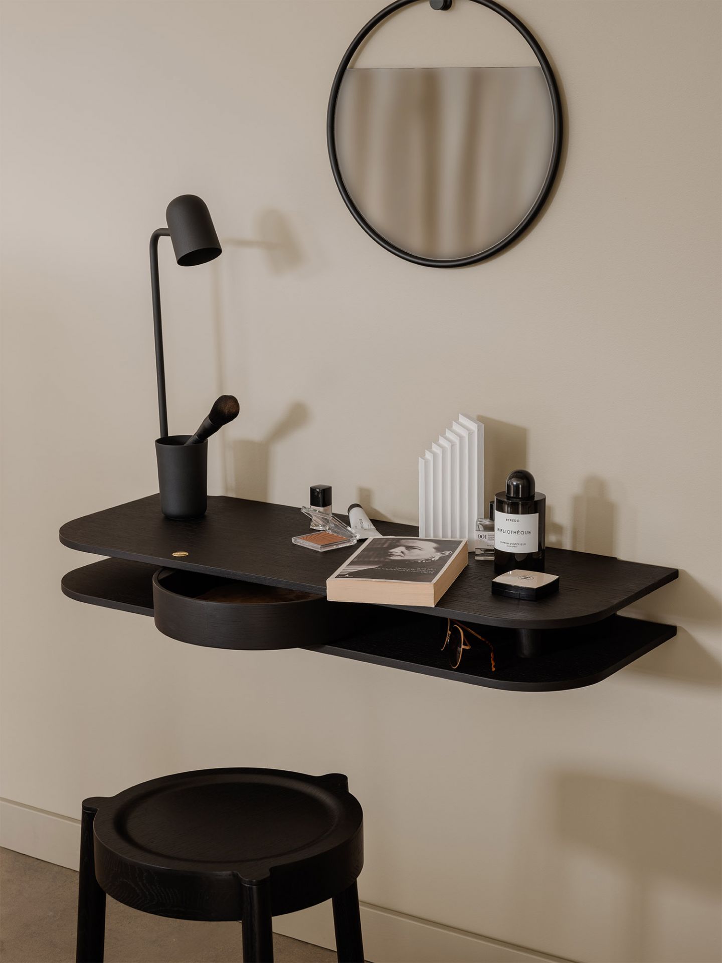 Valet Wandkonsole aus geräucherter Eiche mit Spiegel, Lampe und Accessoires an beiger Wand.