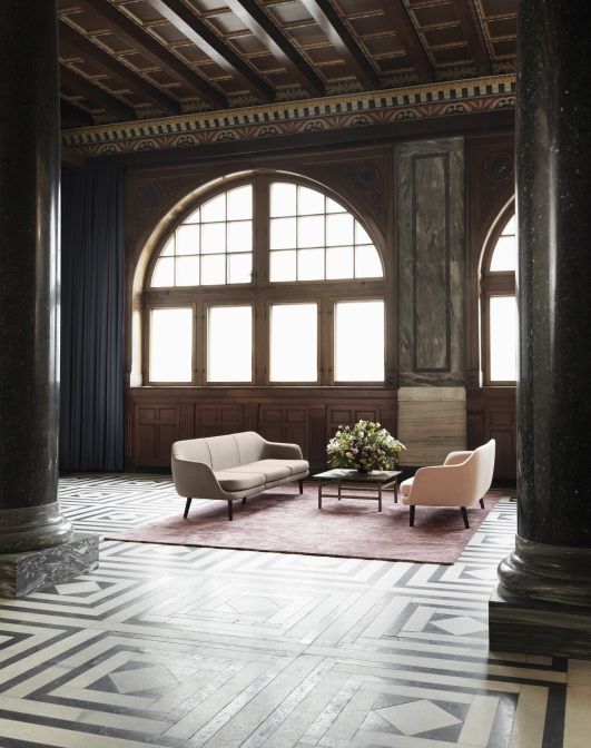 Normann Copenhagen Grow Table Couchtisch mit Sofa und Sessel auf einem Teppich in einem Raum.