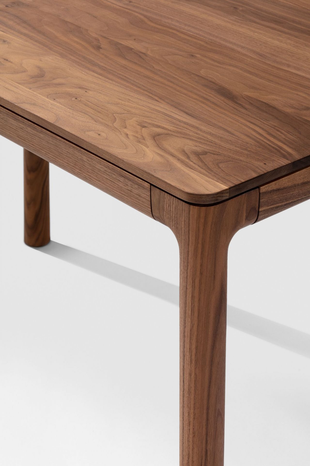 Detailaufnahme des M11 Tisches: Massivholz Tischplatte und Beine aus edlem Nussbaumholz.