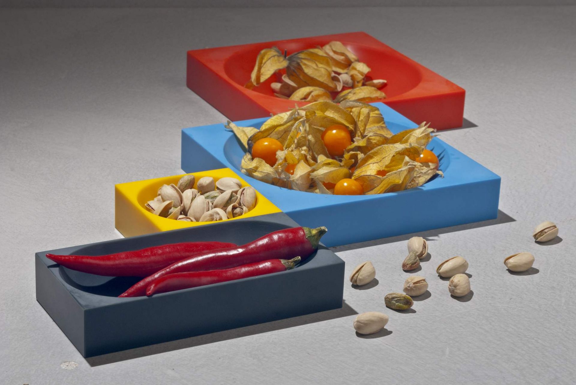 Farbenfrohe Modul 2 Magnetic Bowl Schalen mit Physalis, Pistazien und roten Chilis. Dekorative Schalen für Küche und Tisch.