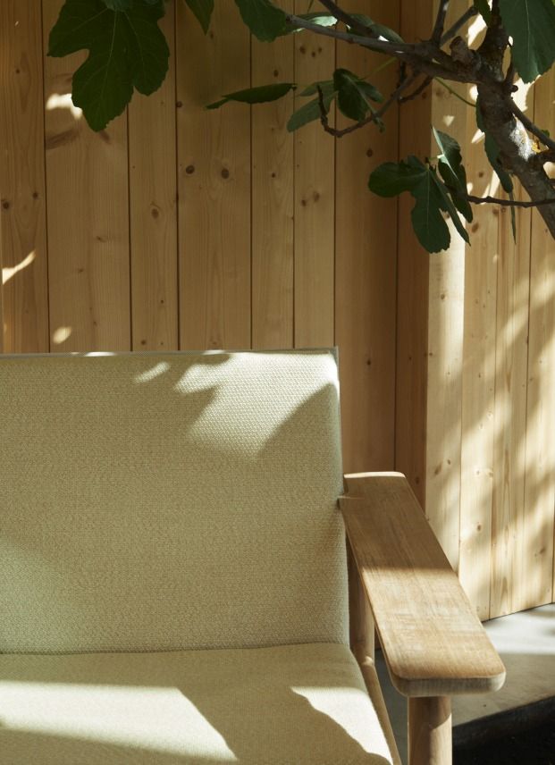 Nahaufnahme des Pelagus Lounge Sessel von Skagerak by Fritz Hansen mit hellem Stoffbezug und Holzarmlehne.