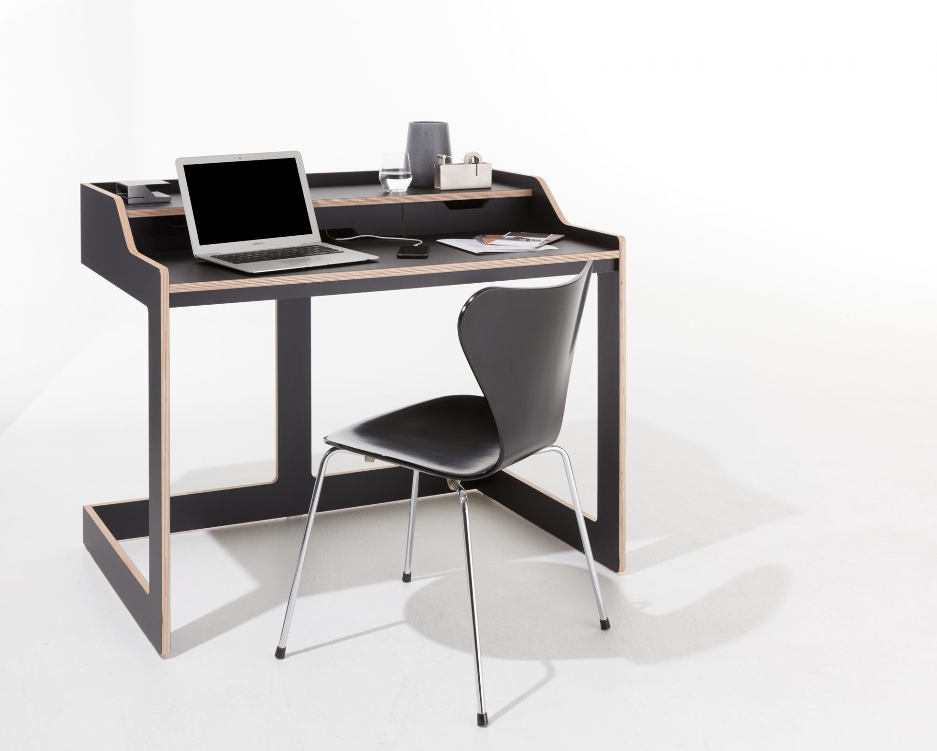 Schwarzer Plane Sekretär von Müller Möbelwerkstätten mit Laptop und Stuhl auf weißem Hintergrund.