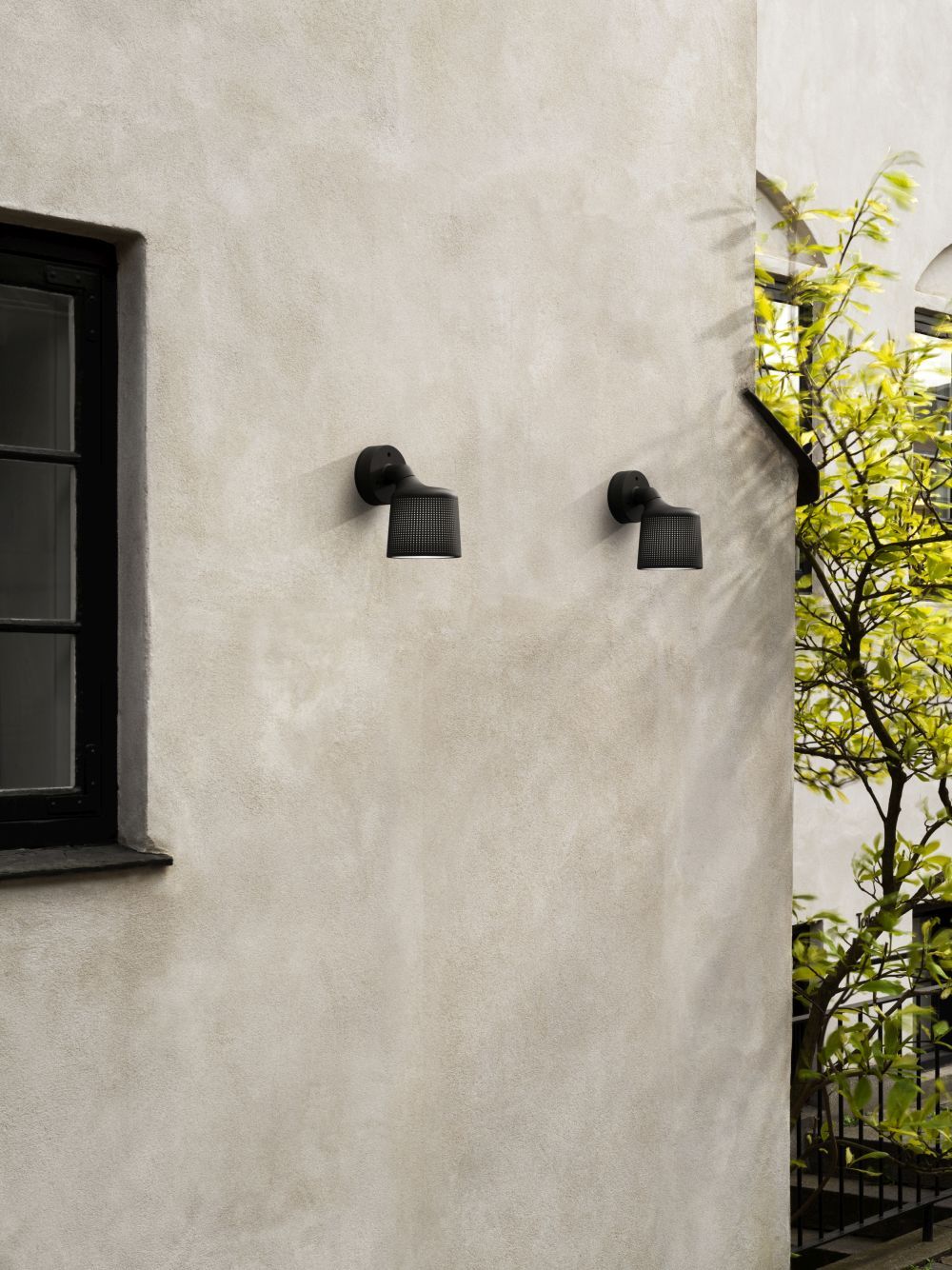 Zwei schwarze Vipp Wandspots als Außenbeleuchtung an einer hellen Hauswand montiert.