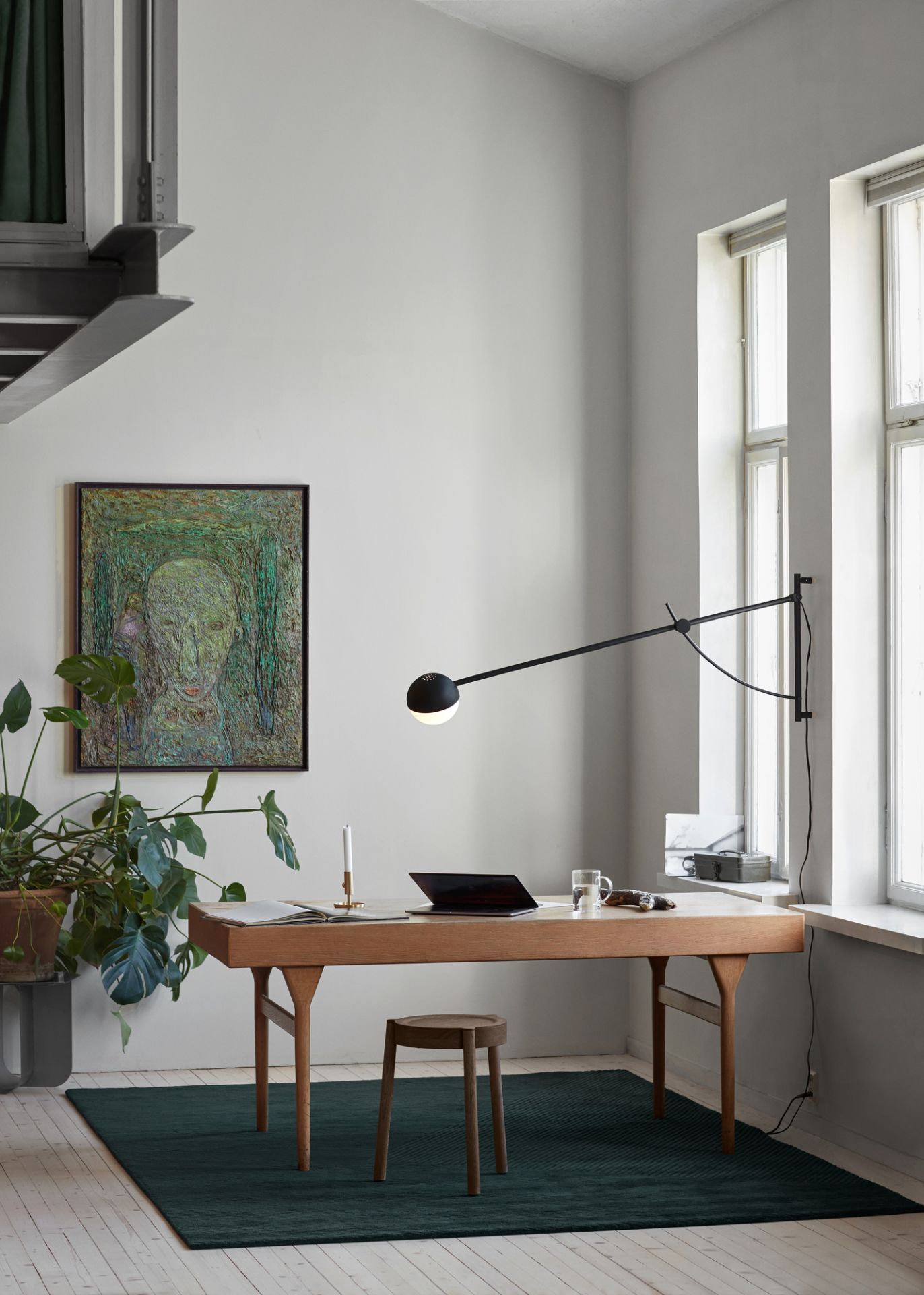 Büro mit Northern Balancer Wall Wandleuchte in Schwarz, die einen Schreibtisch beleuchtet.