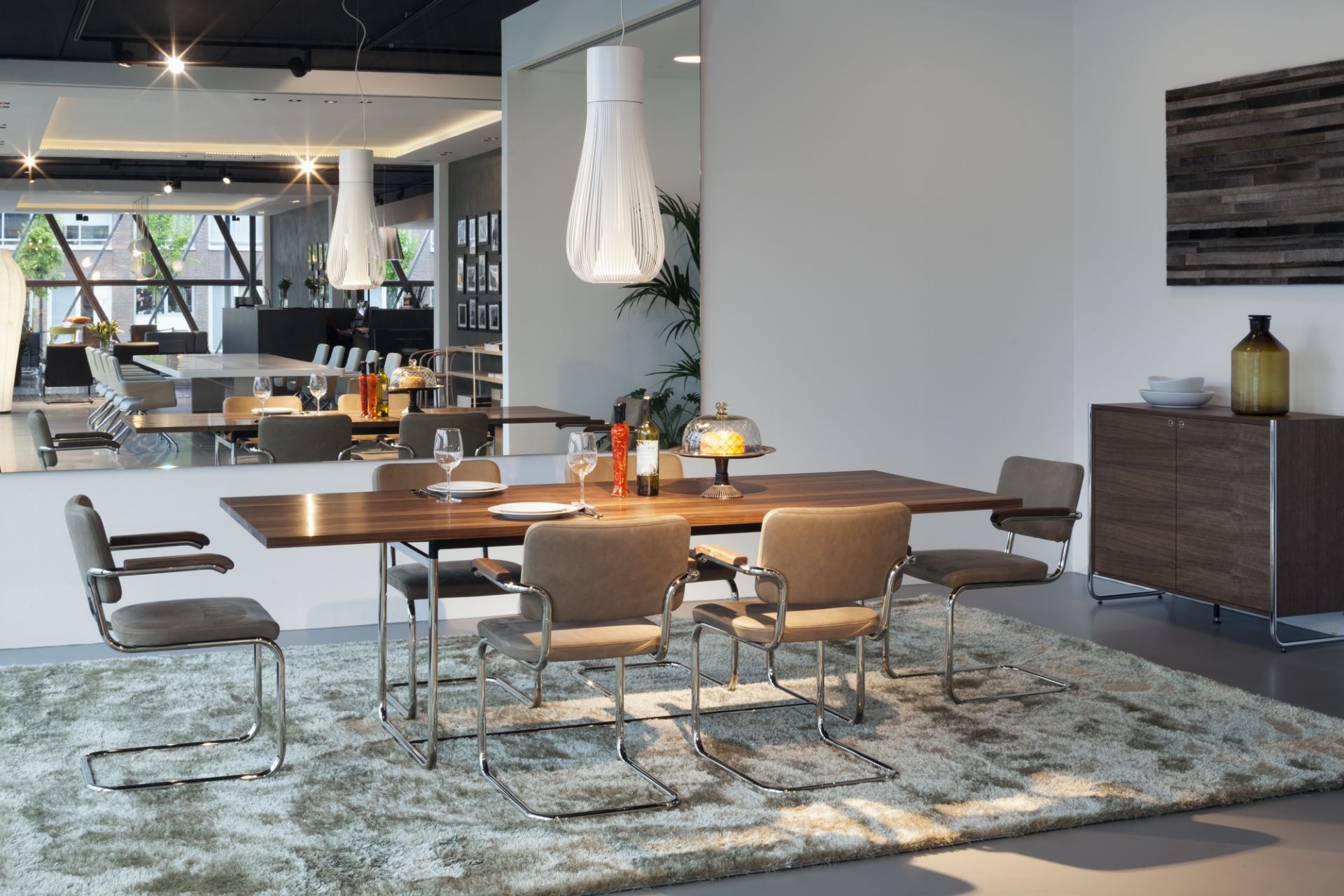 Esszimmer mit Thonet S 1070 Esstisch aus Holz und Freischwinger Stühlen auf einem Teppich.