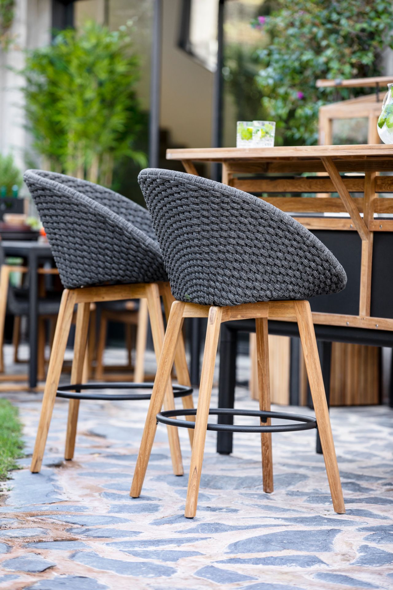 Zwei Cane-Line Peacock Barhocker aus Rattan und Teakholz für den Außenbereich.