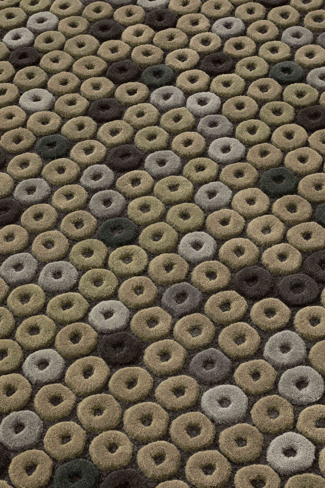 Detailaufnahme des Chimos Rug Teppichs mit Donut-Muster in Braun-, Beige- und Grautönen.
