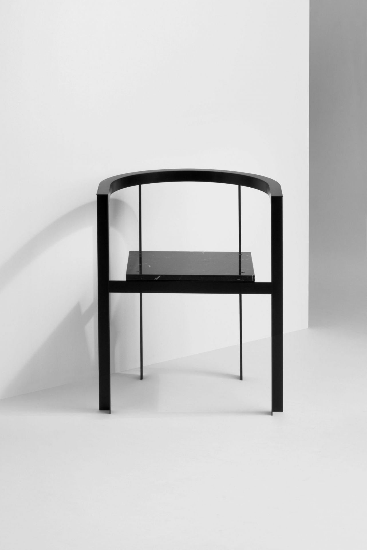 Schwarzer Throne Stuhl von New Tendency mit Sitzfläche aus Marmor vor weißem Hintergrund.