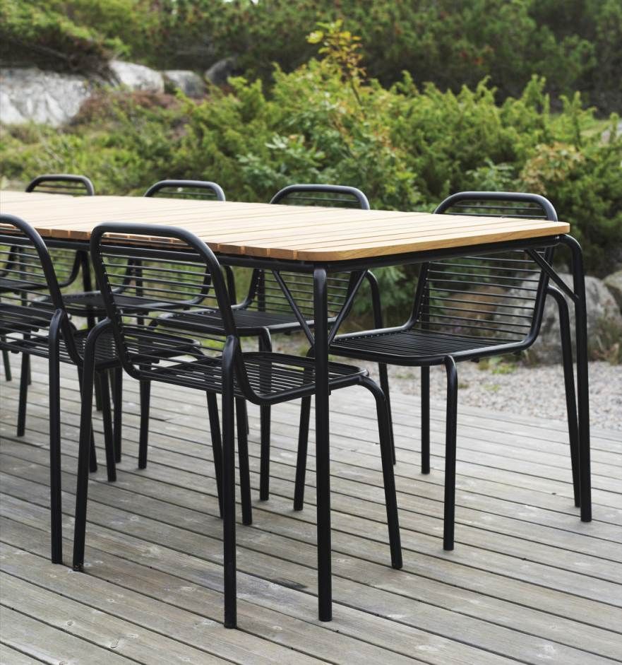 Normann Copenhagen Vig Table 90 x 200 cm Outdoor Tisch mit schwarzen Stühlen auf Holzterrasse.