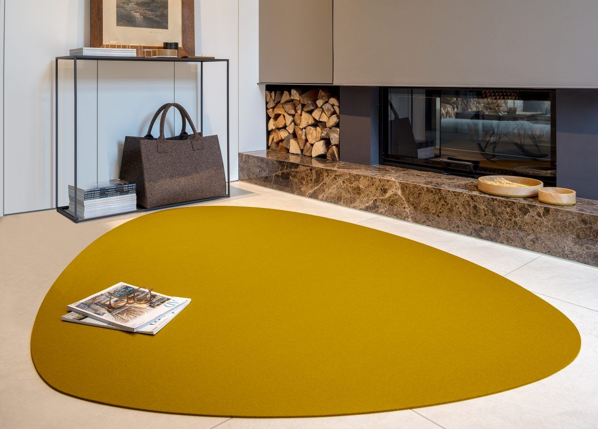 Goldener Hey Sign Stone Teppich aus Filz im modernen Wohnzimmer mit Kamin und Dekoration.