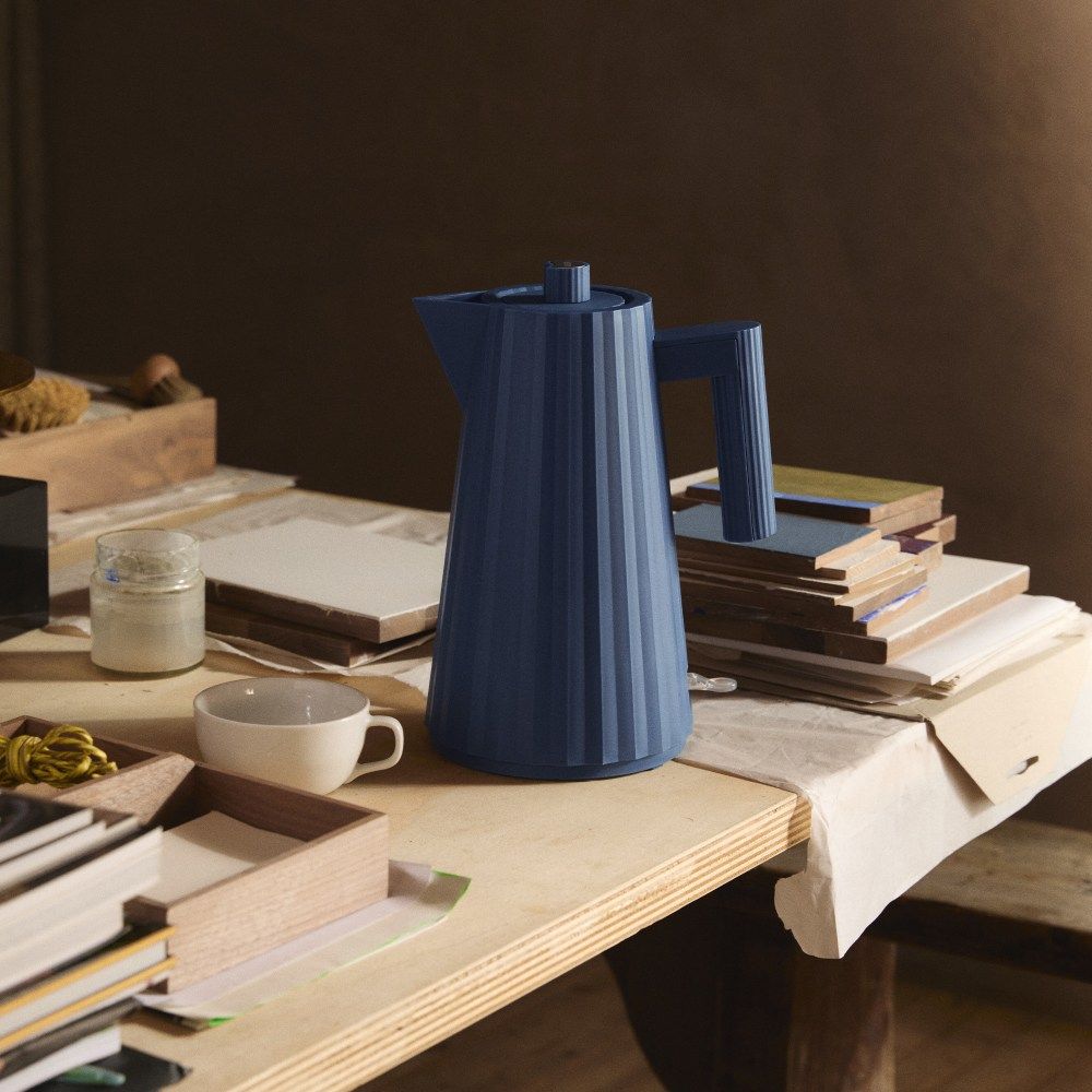 Blauer Alessi Plissé Wasserkocher MDL06 auf einem Tisch, modernes Küchendesign mit Rillenstruktur.