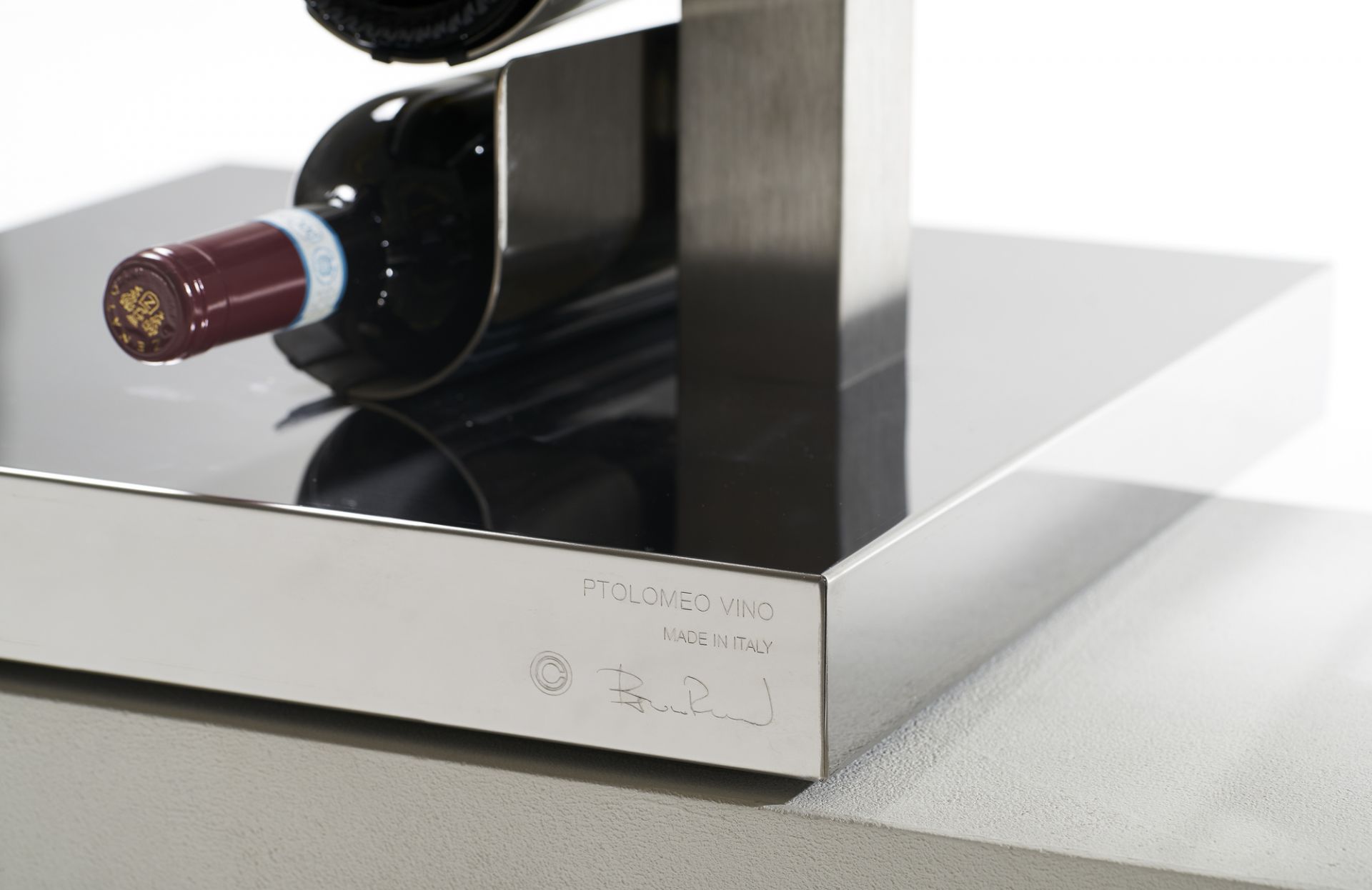 Detailaufnahme des Ptolomeo Vino Weinregals von Opinion Ciatti mit einer liegenden Weinflasche.