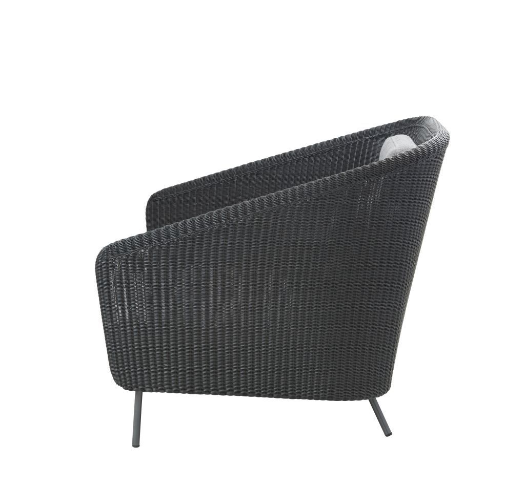 Schwarzer Cane-Line Loungesessel für den Außenbereich, seitliche Ansicht mit Kissen und filigranem Rattan-Geflecht.