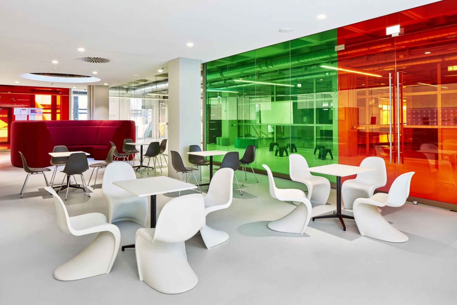 Innenaufnahme: Moderne Cafeteria mit rechteckigen Bistro Tischen und Stühlen von Vitra.