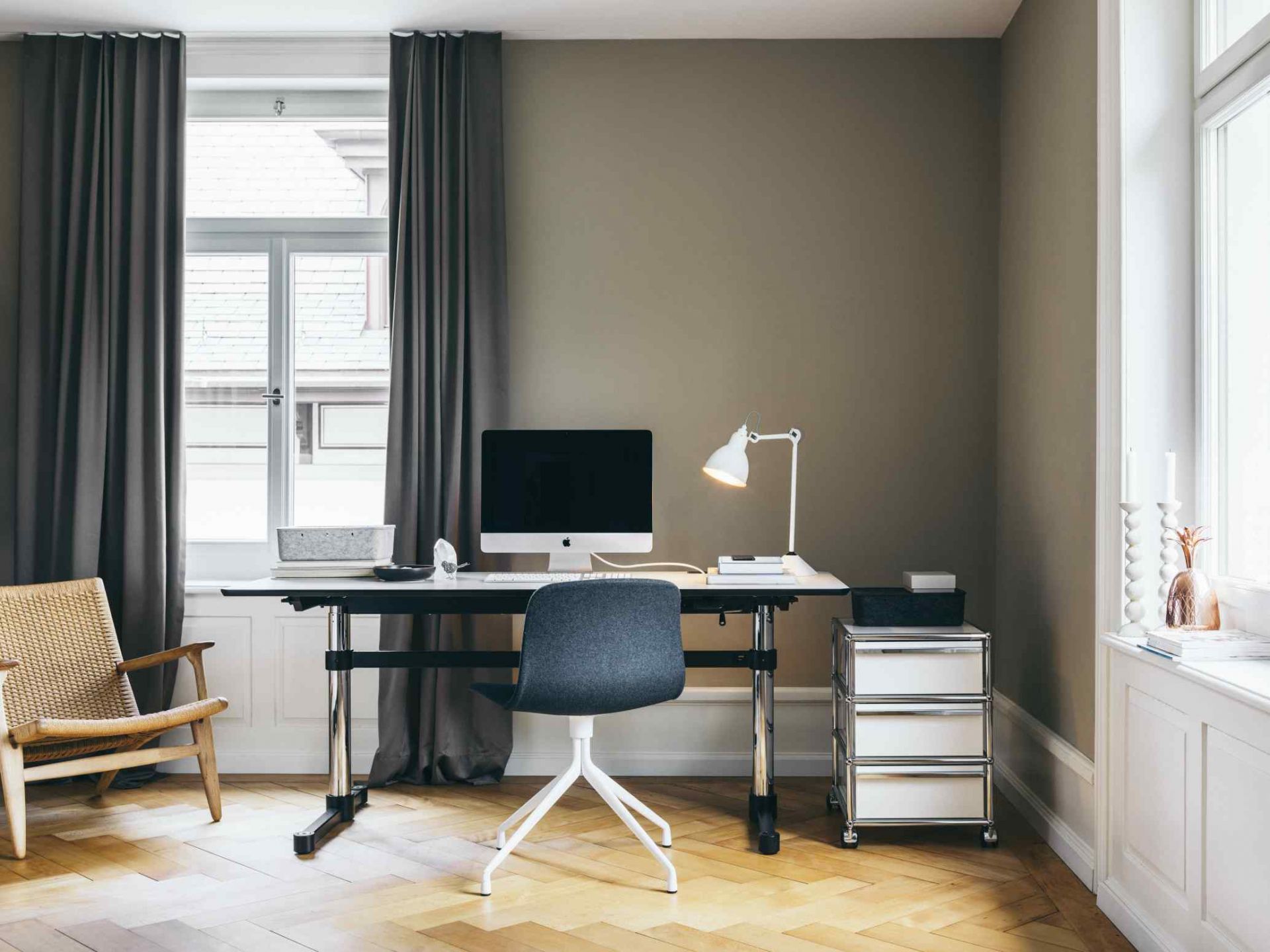 Moderner Arbeitsplatz mit USM Haller Kitos M Schreibtisch in Linoleum nero, Bürostuhl, Lampe und USM Rollcontainer.