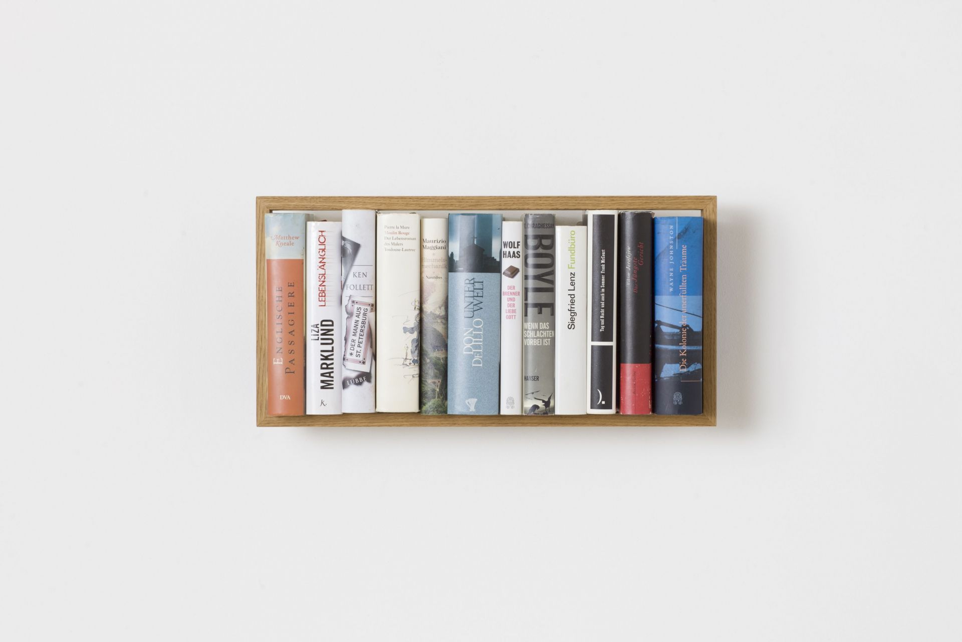 Nahaufnahme des Regal b5 Eiche, ein kleines Wandregal aus Eichenholz, gefüllt mit Büchern.