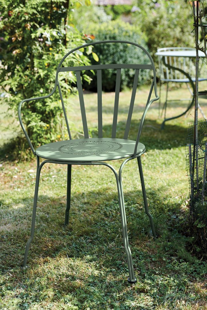 Grüner Louvre Stuhl von Fermob im Garten. Metallstuhl für den Außenbereich mit Armlehnen.