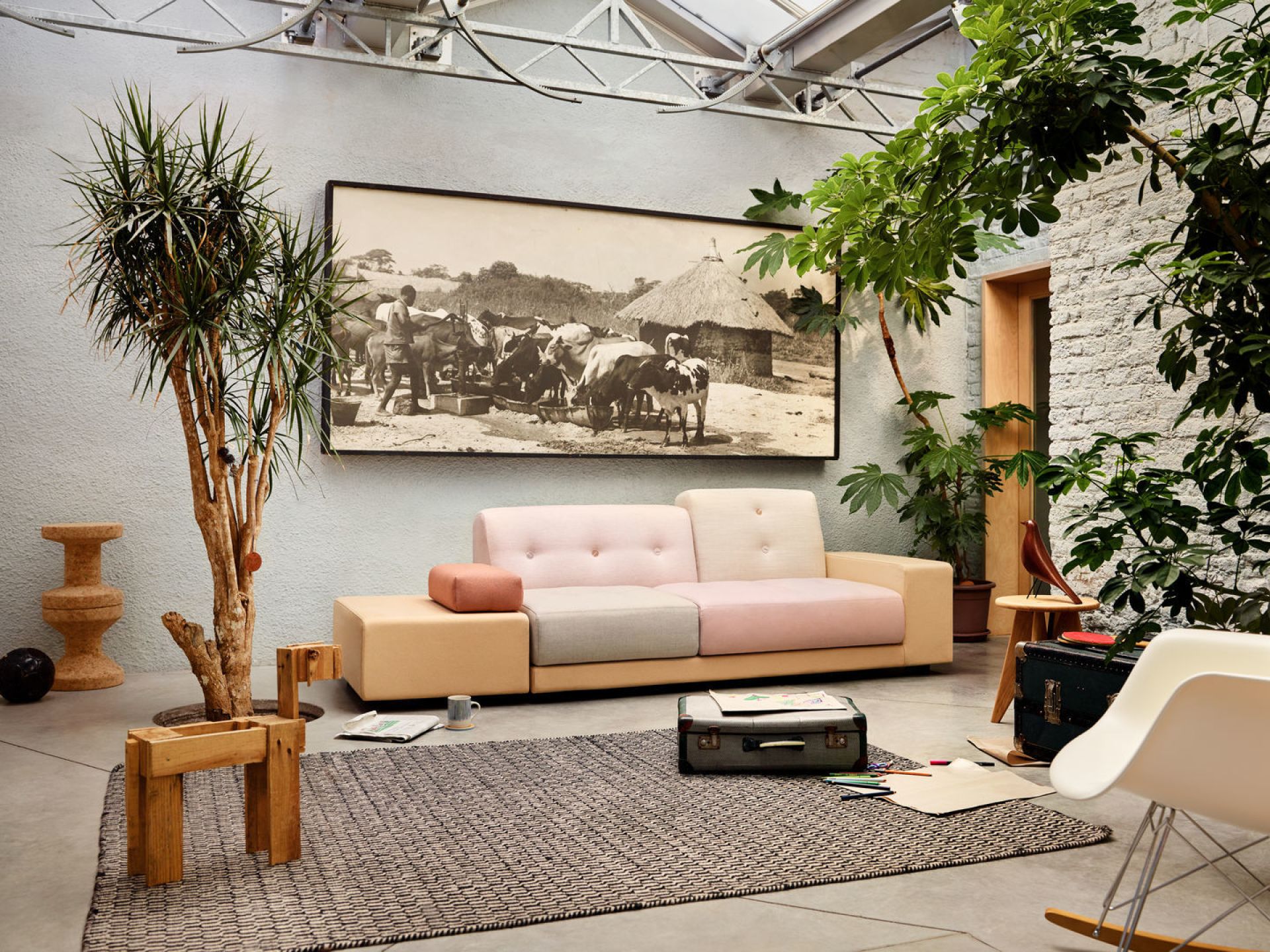 Heller Raum mit Sofa, Teppich und einem weißen Eames Plastic Arm Rocking Chair (RAR) Schaukelstuhl.