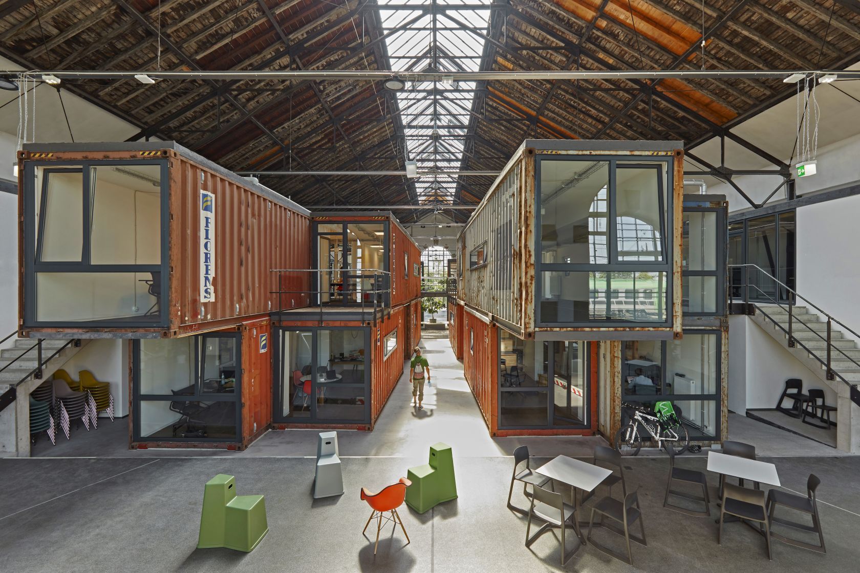 Innenraum mit Eames Plastic Side Chairs und Containern als Büros. Vitra Stühle im Vordergrund.