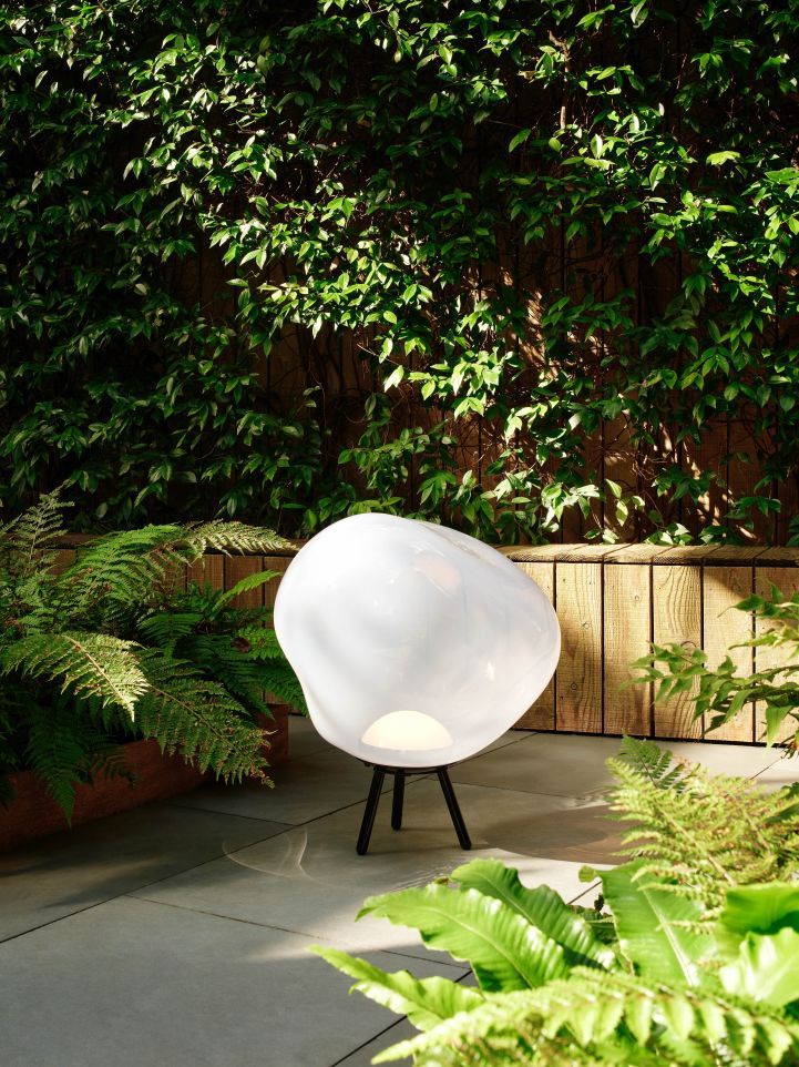 Tom Dixon Melt Large LED Leuchte in Gold als Bodenlampe im Garten.