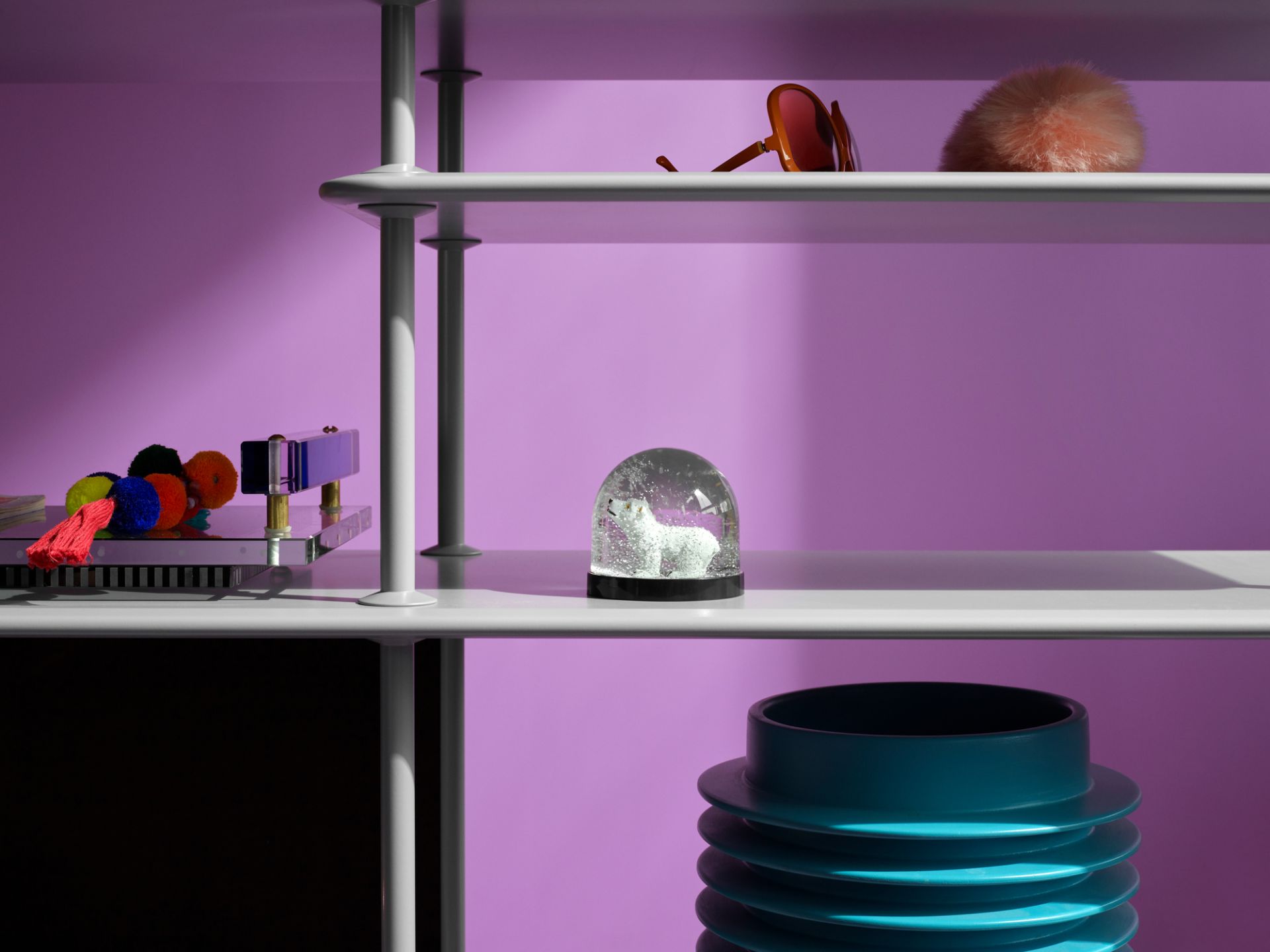 Detailaufnahme des Montana Free Regals mit Accessoires vor lila Hintergrund. Designregal für Wohnzimmer und Büro.