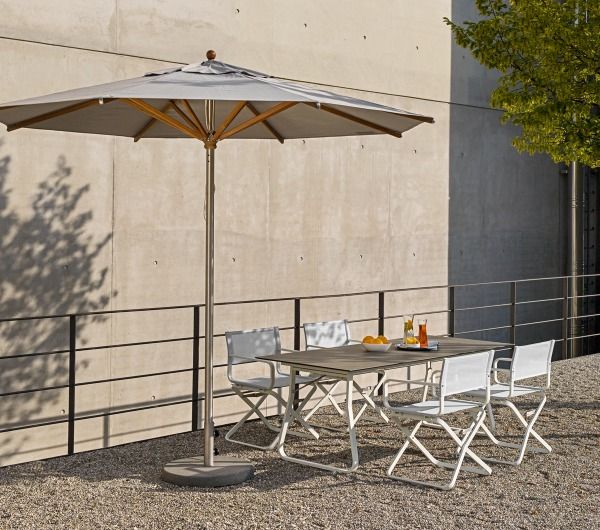 Weishäupl Trend Sonnenschirm über einer Gartentischgruppe mit weißen Klappstühlen und Getränken im Freien.