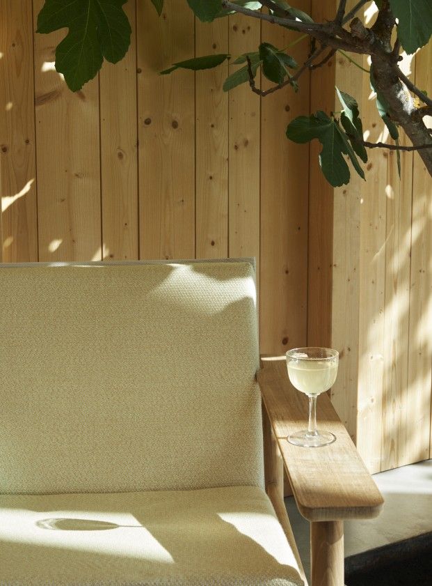 Nahaufnahme des Pelagus Lounge Sessels von Skagerak mit Getränk im Freien.