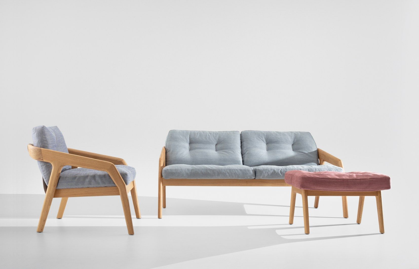Friday Sessel, Sofa und Hocker: Moderne Sitzmöbel mit Holzrahmen und hellblauen Polstern.