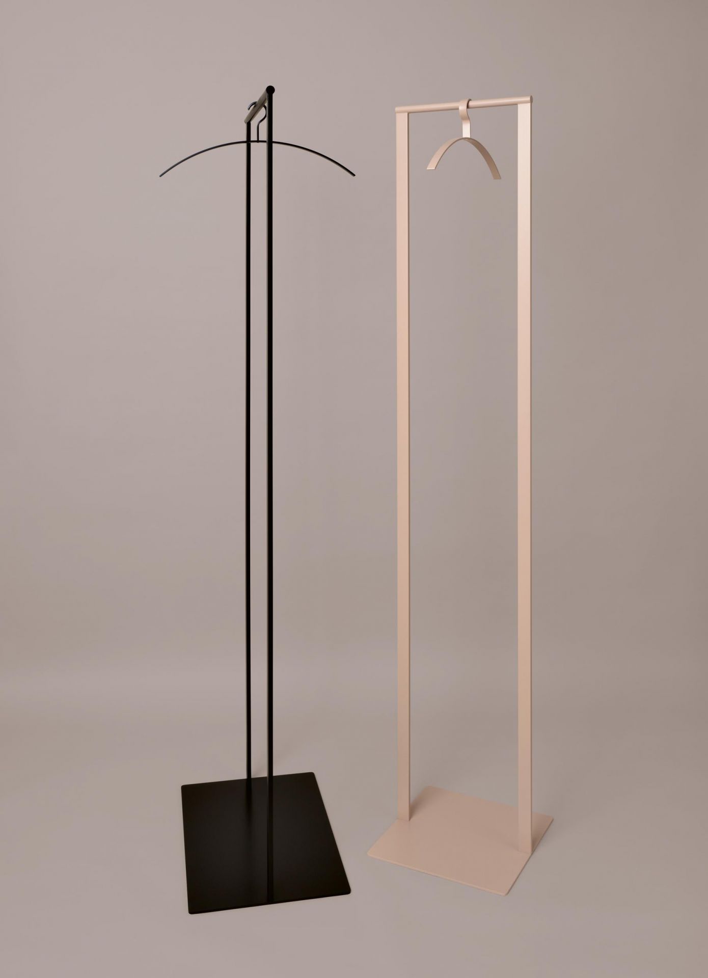 Zwei moderne Schönbuch Garderobenständer: Schwarz mit Bügel, Beige mit Haken, minimalistisches Design.