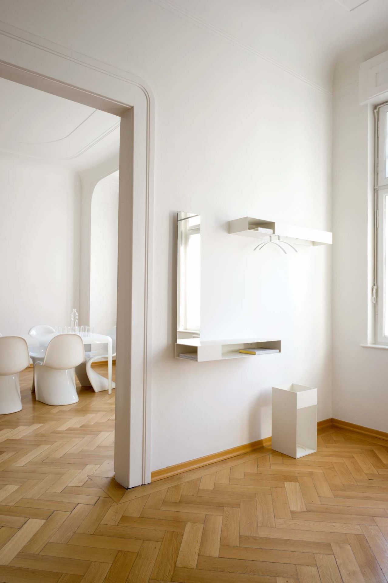 Weißer Schönbuch Match Schirmständer im minimalistischen Flur mit Garderobe und Spiegel. Modernes Design für stilvolle Ordnung.