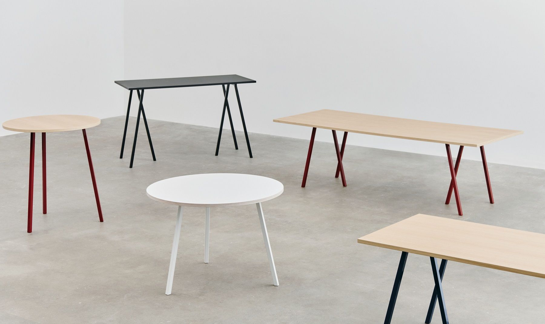 Mehrere Hay Loop Stand Tische in verschiedenen Formen, Farben und Größen in einem Raum.