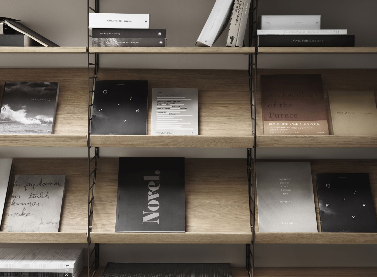 String Regalsystem mit Fachböden in Holzoptik, dekoriert mit Büchern. Modernes Wandregal für Wohnzimmer.