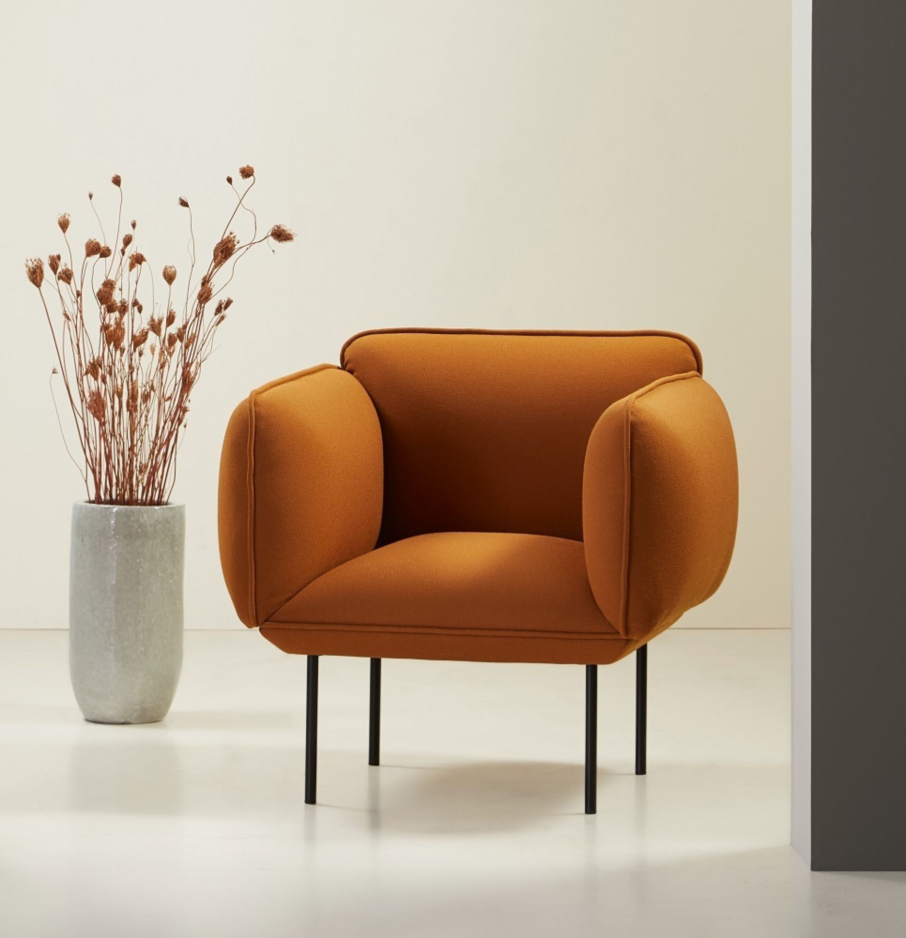 Nakki Sessel von Woud, orangefarbener Polstersessel mit schwarzen Beinen und minimalistischem Design.