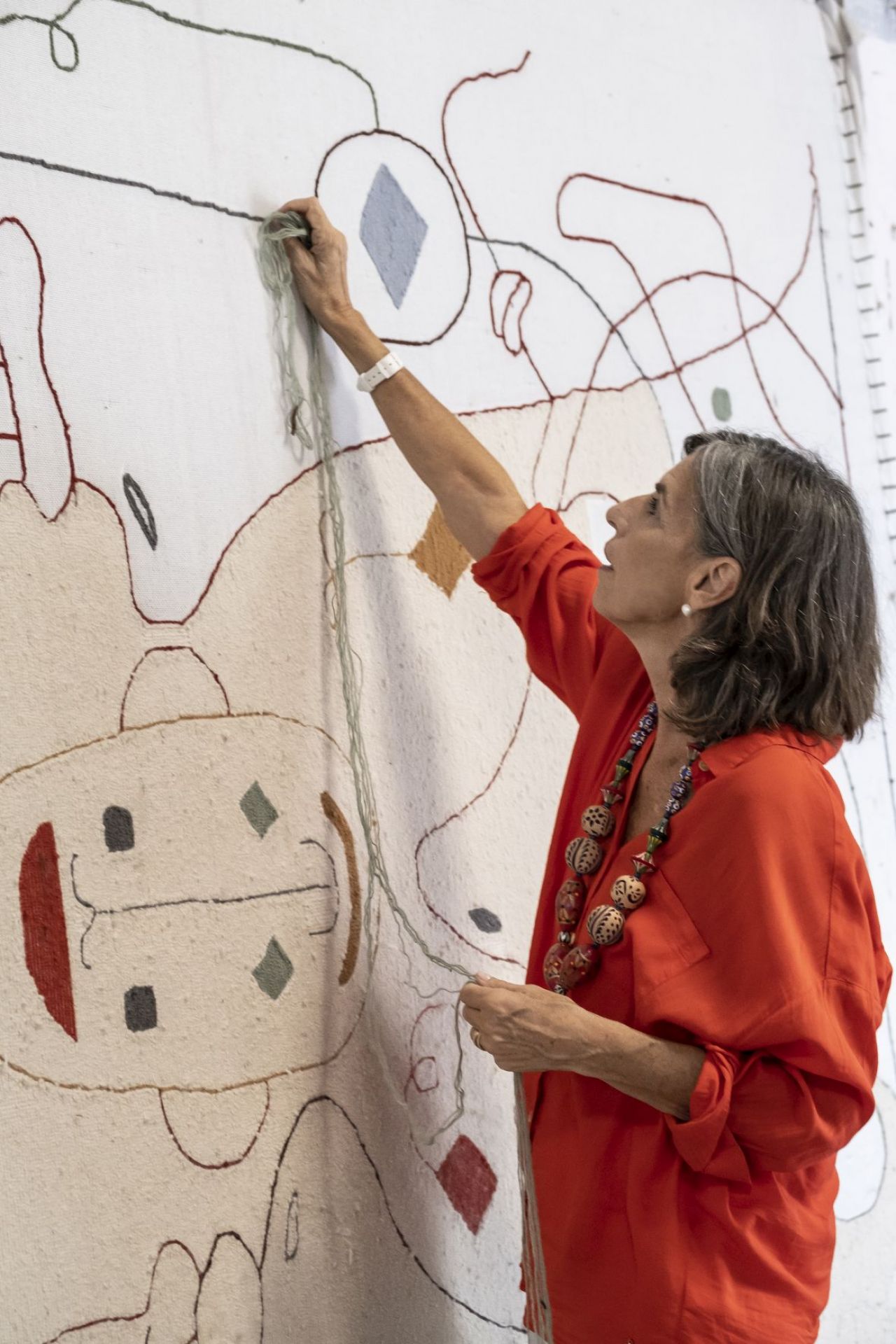 Frau arbeitet an einem Nanimarquina Silhouette Teppich. Handgefertigter Outdoor Teppich mit abstraktem Muster.