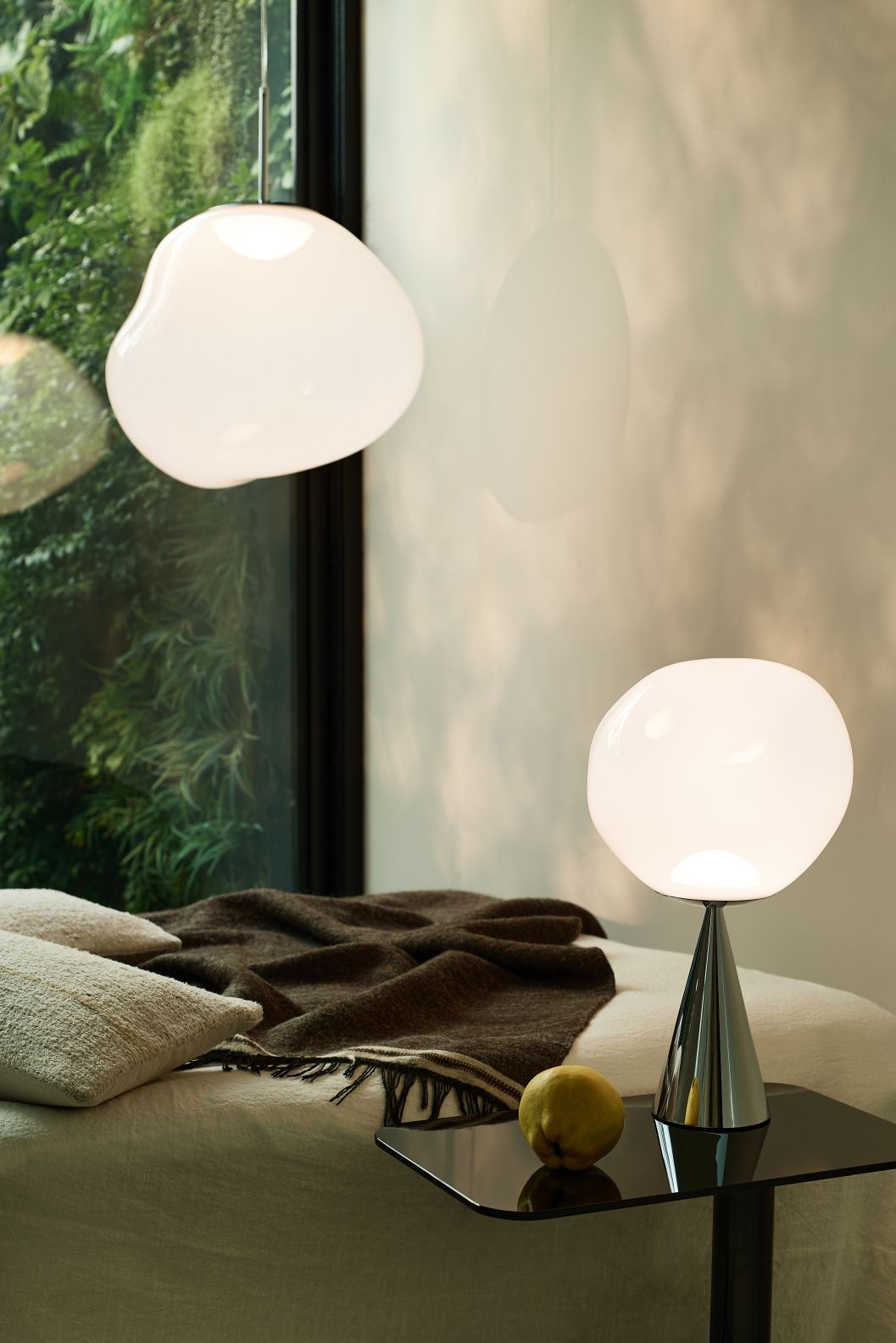 Nahaufnahme: Tom Dixon Melt Pendelleuchte in Opal-Silber und Tischleuchte, modernes Design.