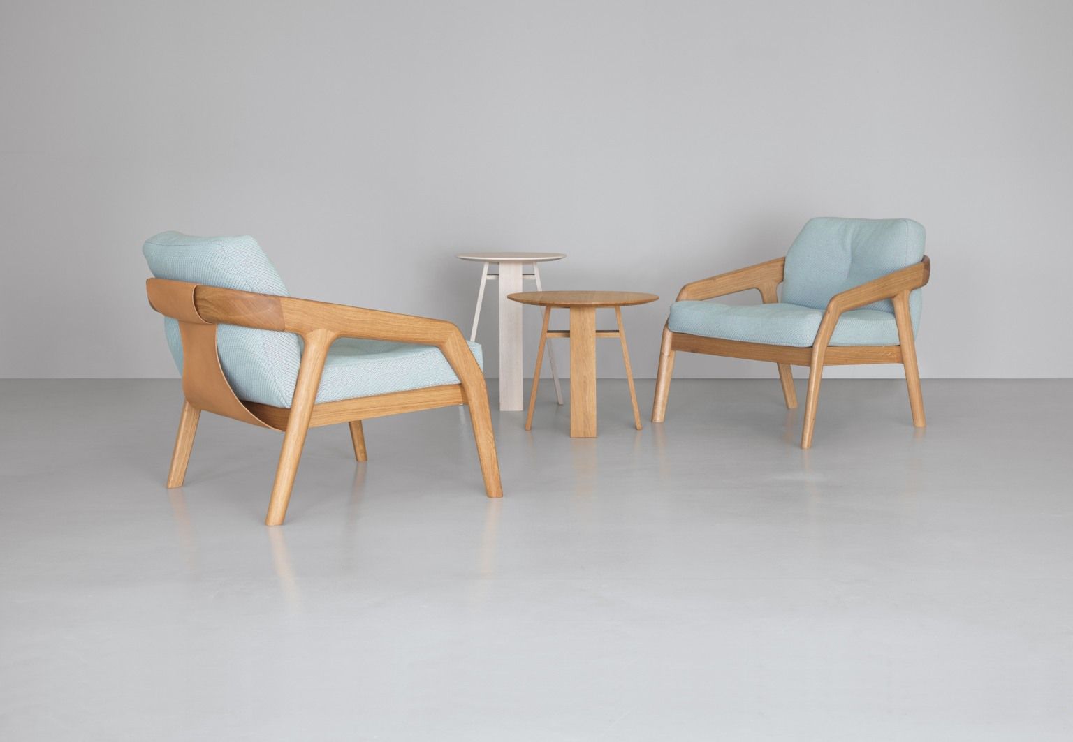 Zwei Friday Sessel mit hellblauem Bezug und Holztischen, moderne Möbel für Wohnzimmer.