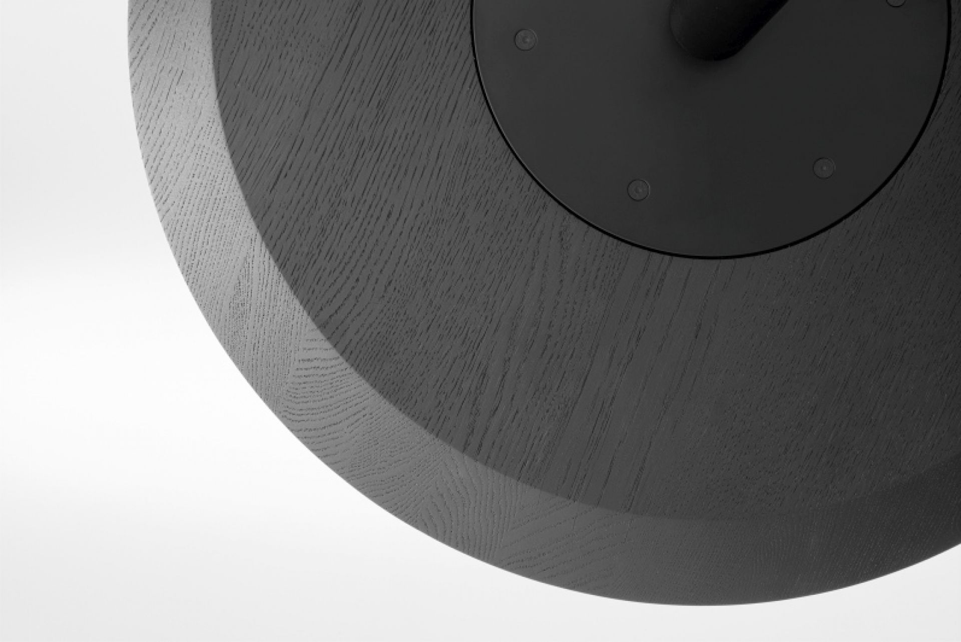 Detailaufnahme der schwarzen Tischplatte des Vermu High Stehtischs mit sichtbarer Holzmaserung und Befestigungsplatte.