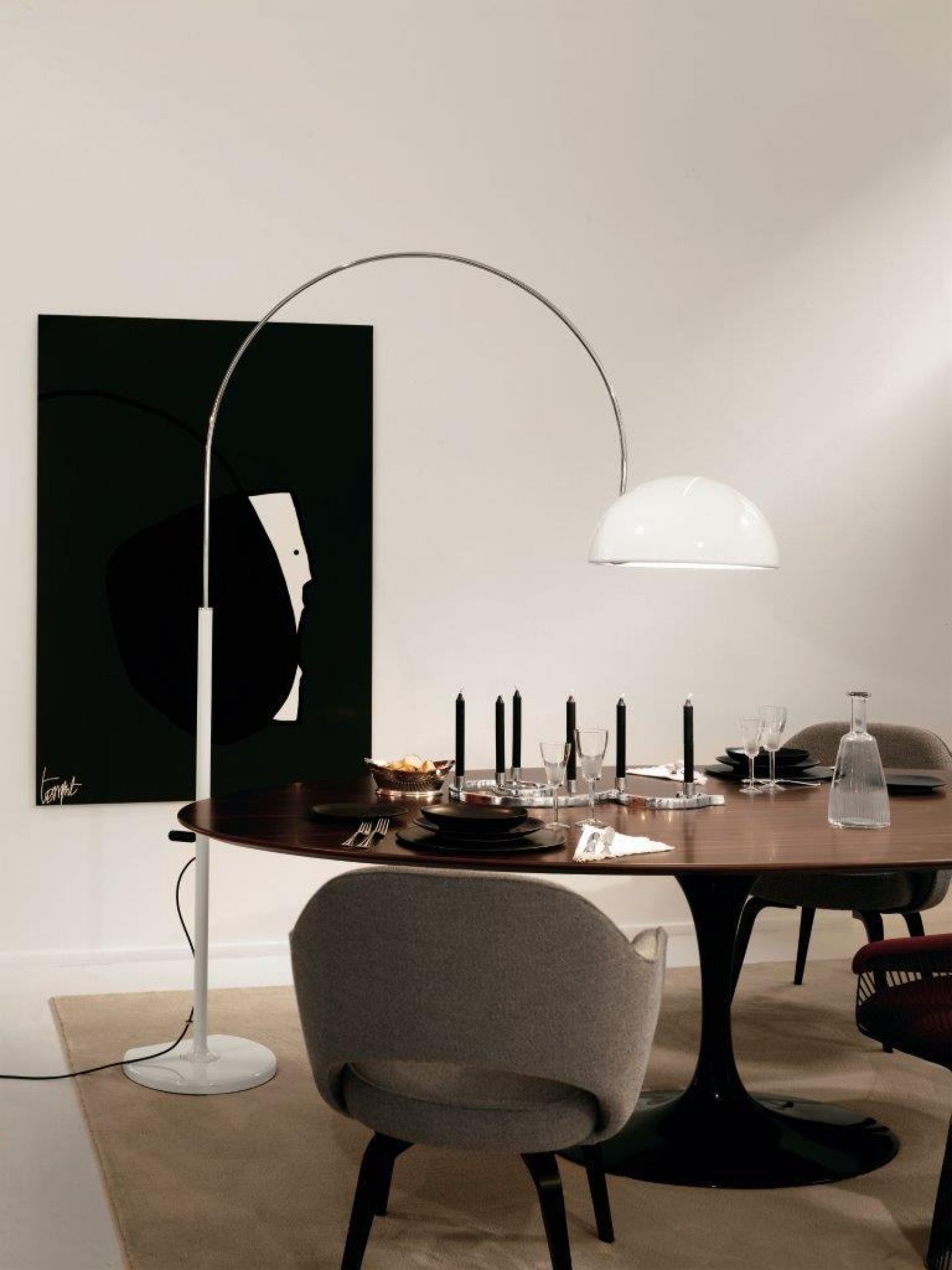 Coupé Stehleuchte von Oluce, schwarz, über Esstisch mit Gedeck und Dekoration. Design Stehlampe.