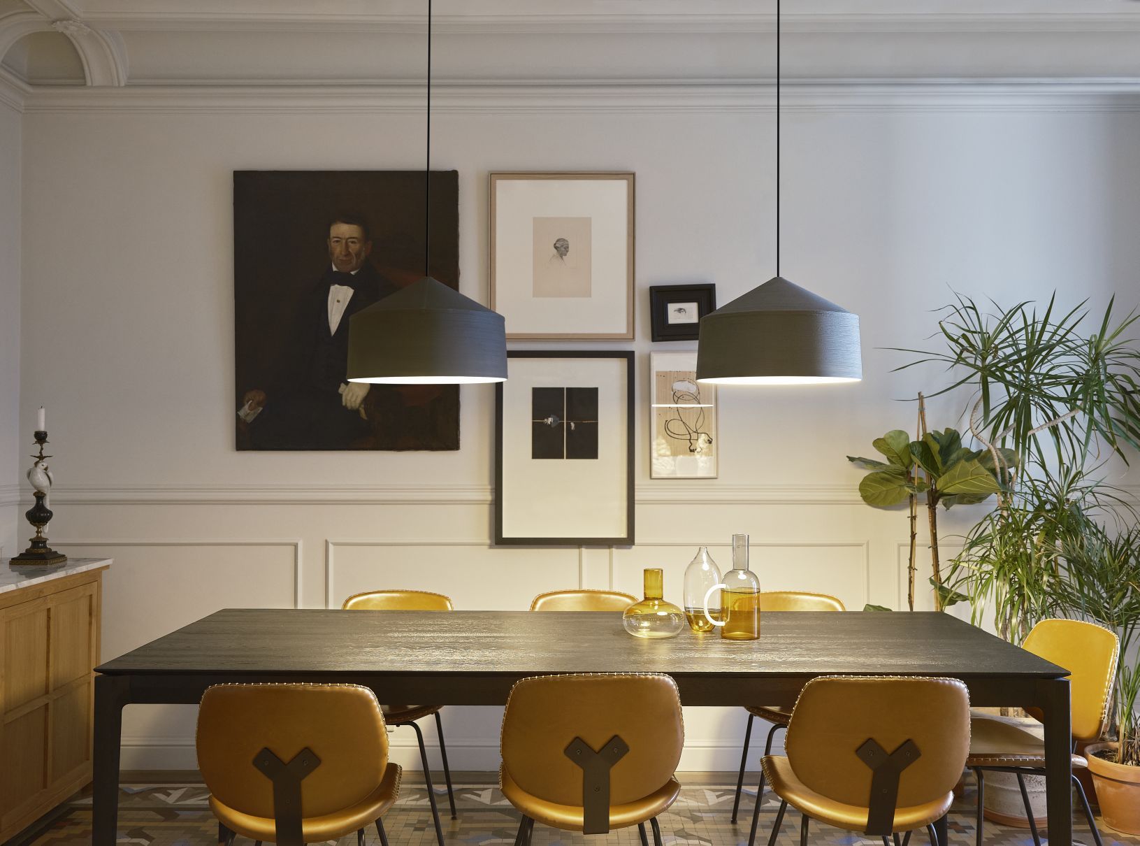 Zwei graue Zenc Pendelleuchten von Marset hängen über einem Esstisch in einem stilvollen Esszimmer.