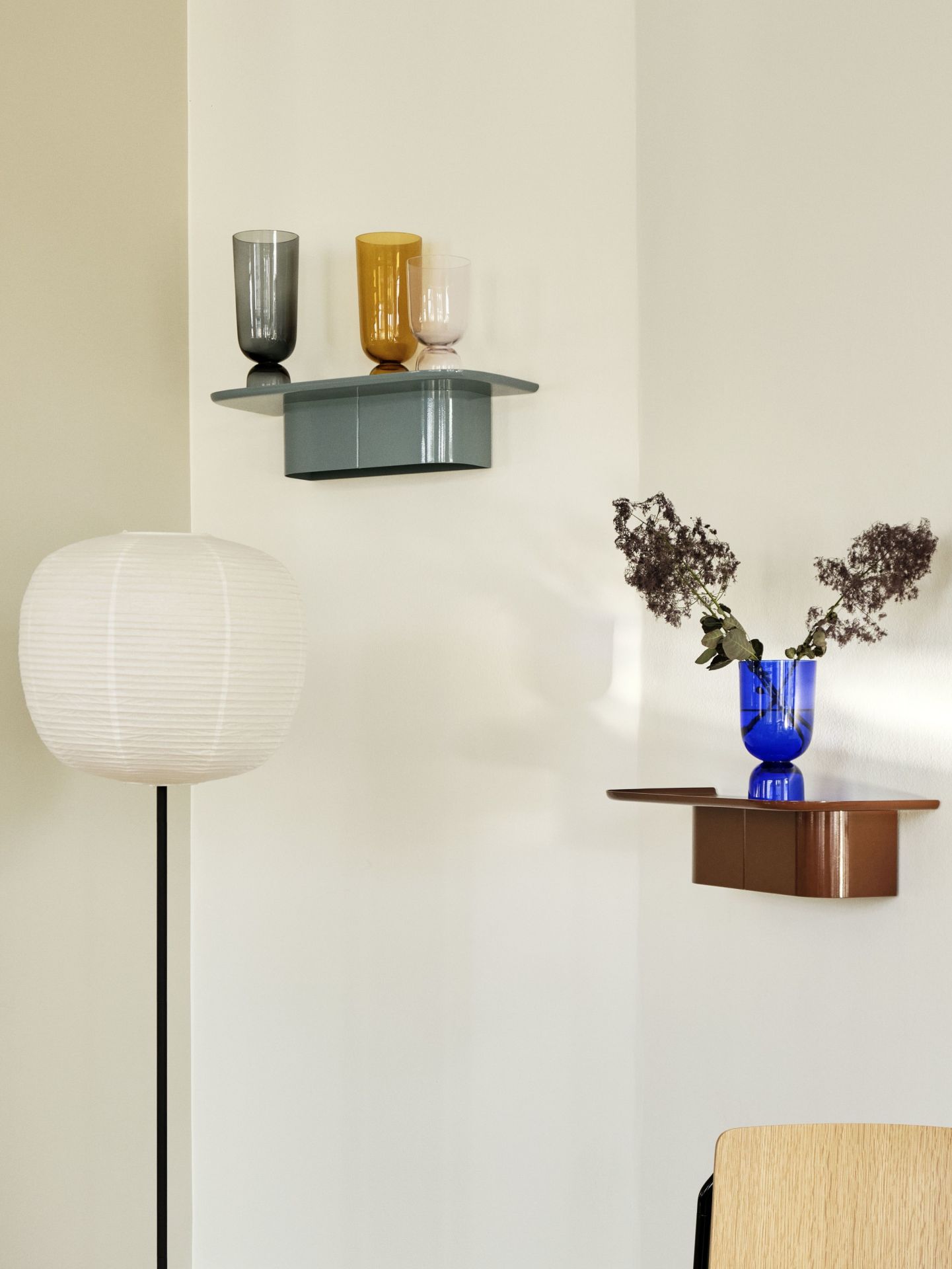 Nahaufnahme von zwei Hay Korpus Wandregalen in Blau und Braun mit Vasen und Dekoration.