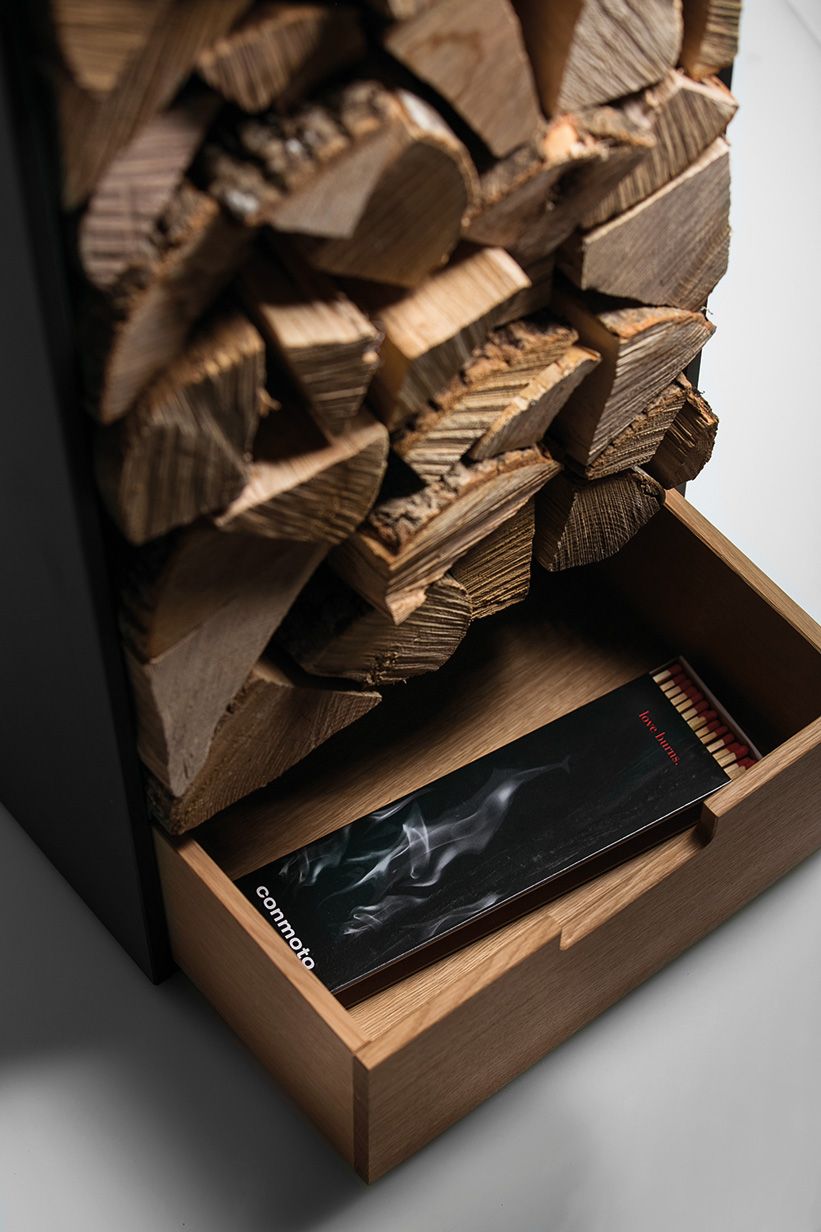 Covo Brennholzregal von Conmoto mit Holzscheiten und Streichhölzern im Schubfach. Modernes Kaminholzregal.