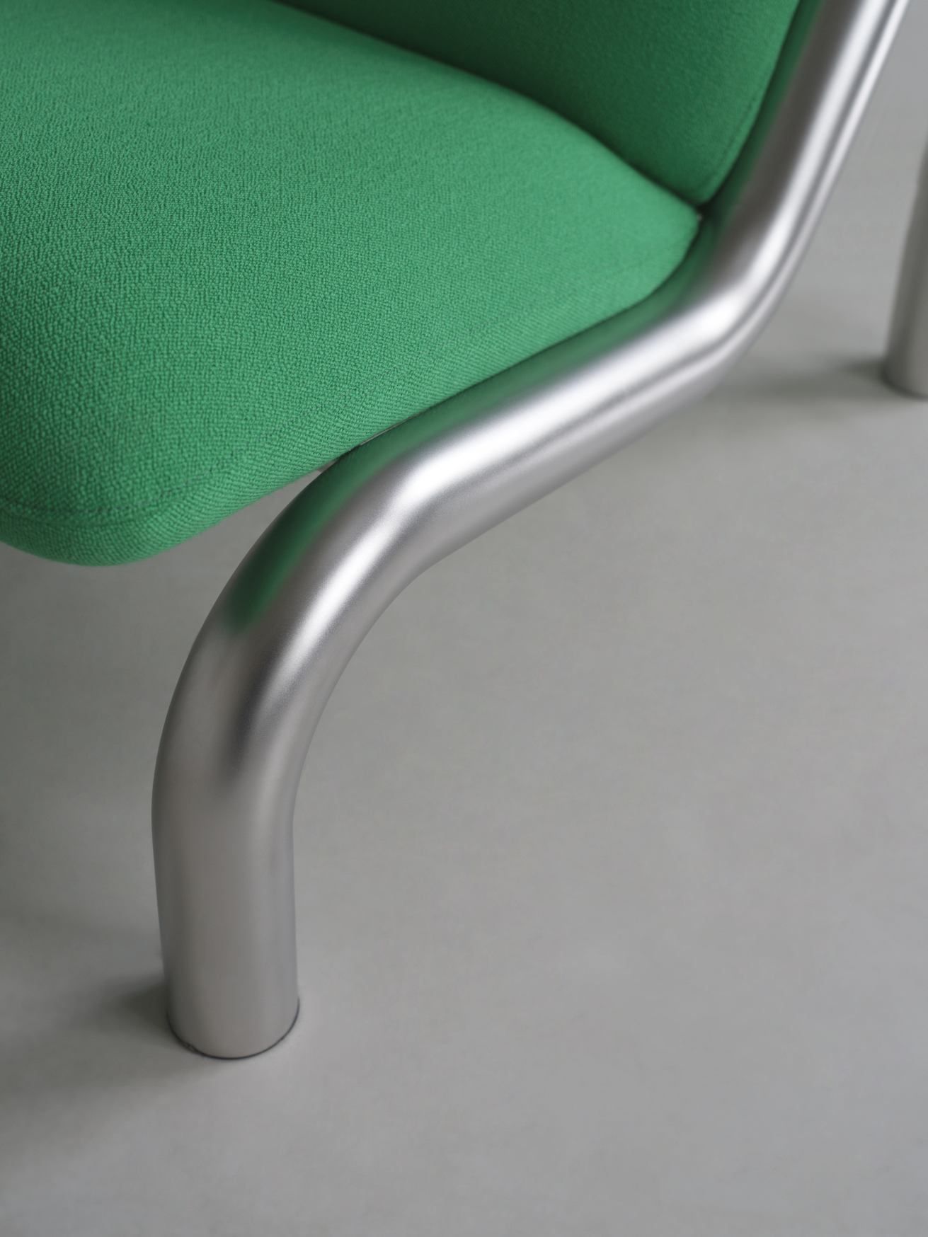 Detailaufnahme vom grünen Normann Copenhagen Tube Lounge Chair Sessel mit silbernem Metallrahmen.