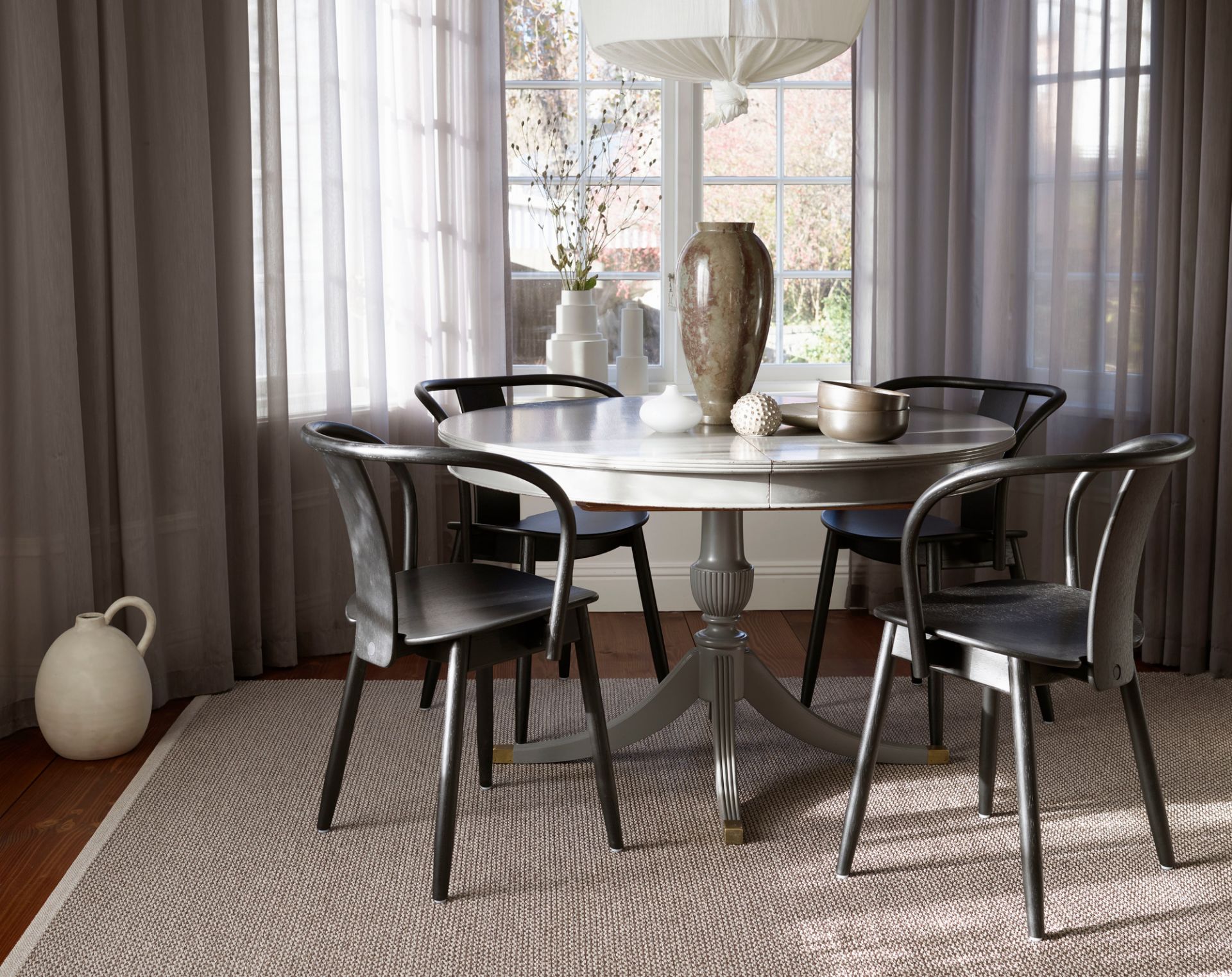 Svea Kunststoffteppich von Pappelina, 140x220 cm, in einem Esszimmer unter einem runden Tisch.