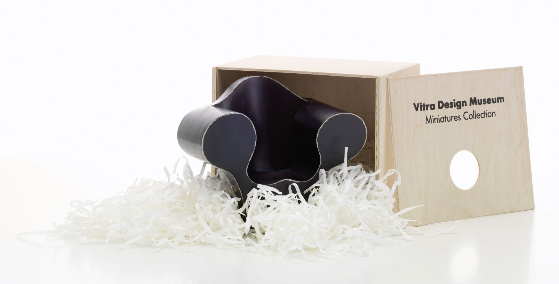 Miniatur des Big Easy Sessels von Vitra in einer Holzkiste mit Füllmaterial.