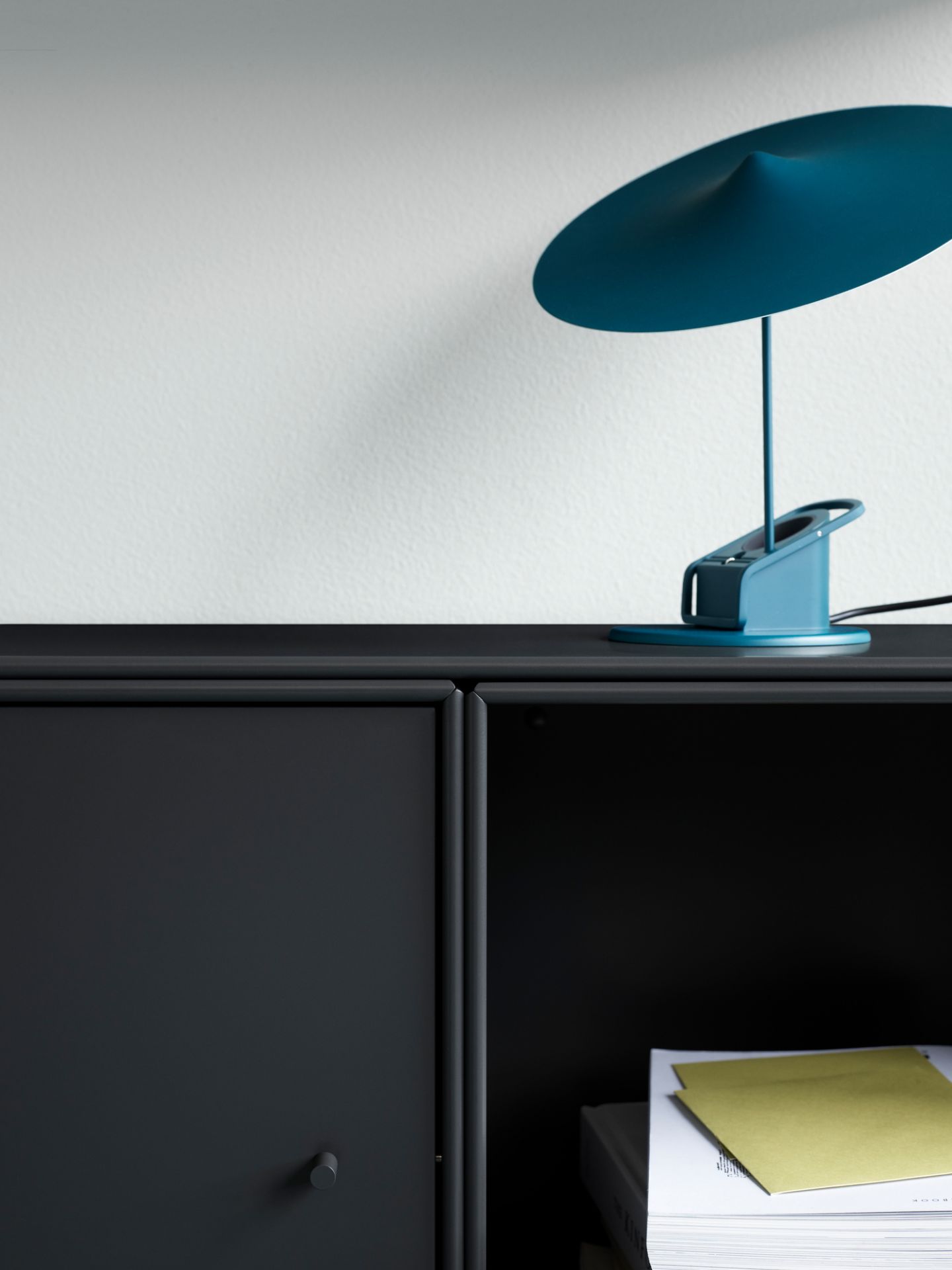 Detailaufnahme: Dunkelgraues Montana Mini Modul mit Regalböden und blauer Lampe. Möbel für stilvolles Wohnen.