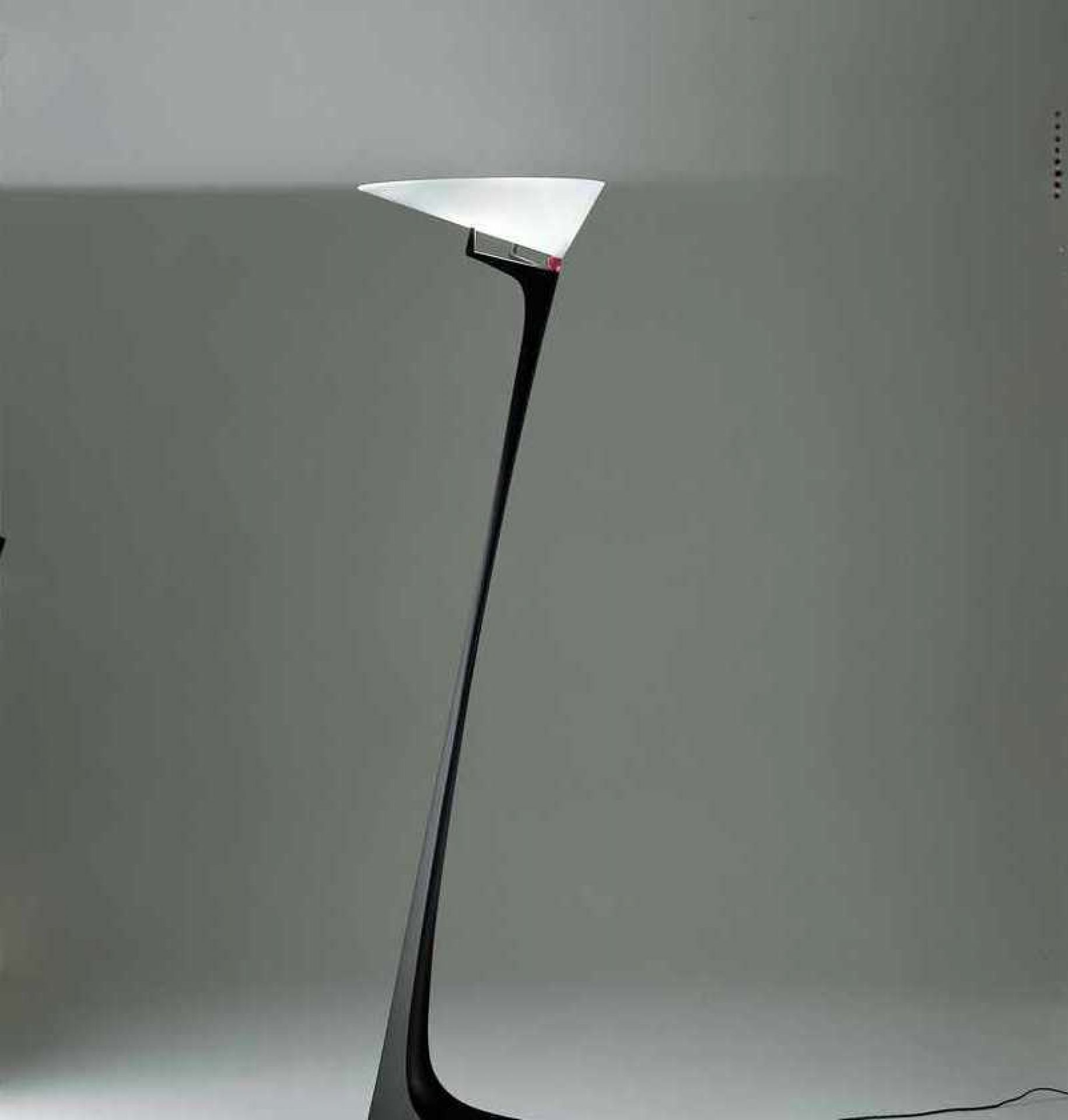 Elegante Montjuic Stehleuchte von Artemide mit schwarzem Fuß und weißem, dreieckigem Lampenschirm.